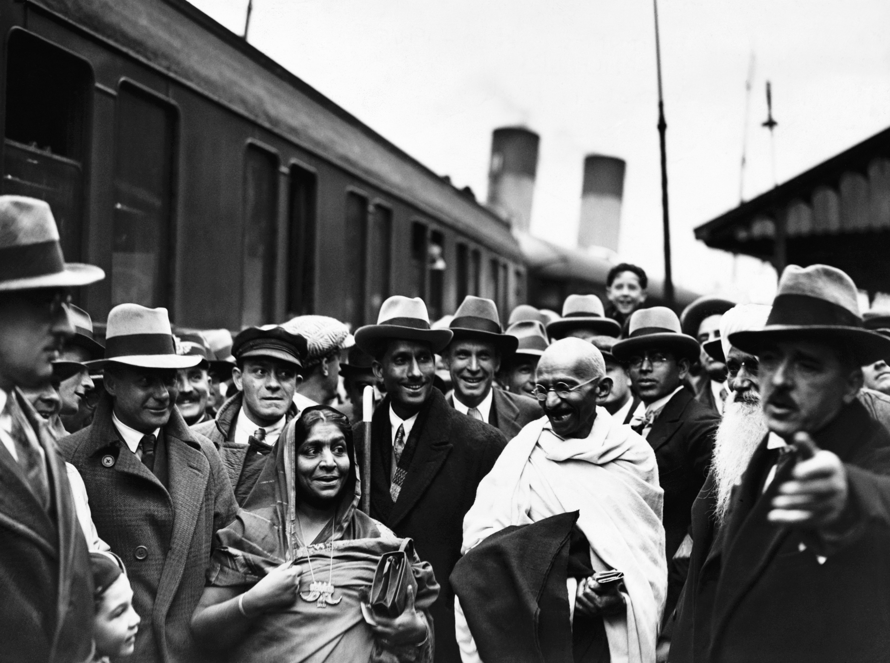 (Original Caption) Original caption: Arrival Of Mahatma Gandhi. Additional Hulton Text: Gandhi arrived in England today to attend the Round Table Conference as the representative of the Indian Nationals. Photo shows: Gandhi photographed on Boulogne Station with Mrs Sarojini Naidu. Information from photo: Gandhi; Mohandas Karamchand, known as Mahatma: (1869-1948) Indian leader, born in Porbandar, Kathiawar. He studied law in London, & in 1893 he have up a Bombay legal practice worth ?5000 a year to live on ?1 a week in South Africa, where he spent 21 years opposing discriminatory legislation against Indians. In 1914 he returnerd to India. While supporting the British in WW1, he took an increasing interest in the Home Rule movement (swaraj), over which he soon obtained a personal dominance, becoming master of the congress organization. His civil disobedience campaign of 1920 in (Photo by © Hulton-Deutsch Collection/CORBIS/Corbis via Getty Images)