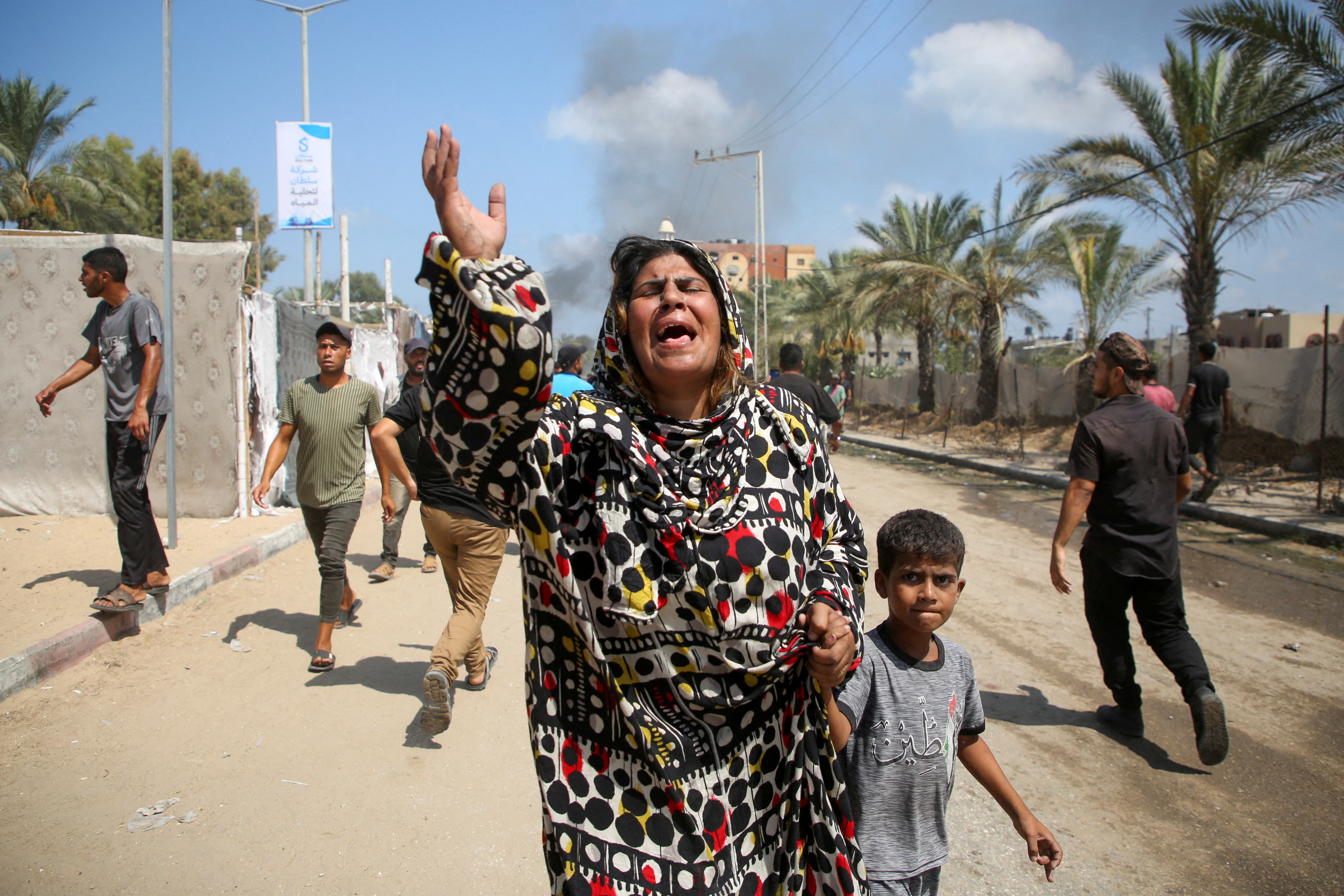 People reacts at the site of what Palestinians say was an Israeli strike at a tent camp in Al-Mawasi area