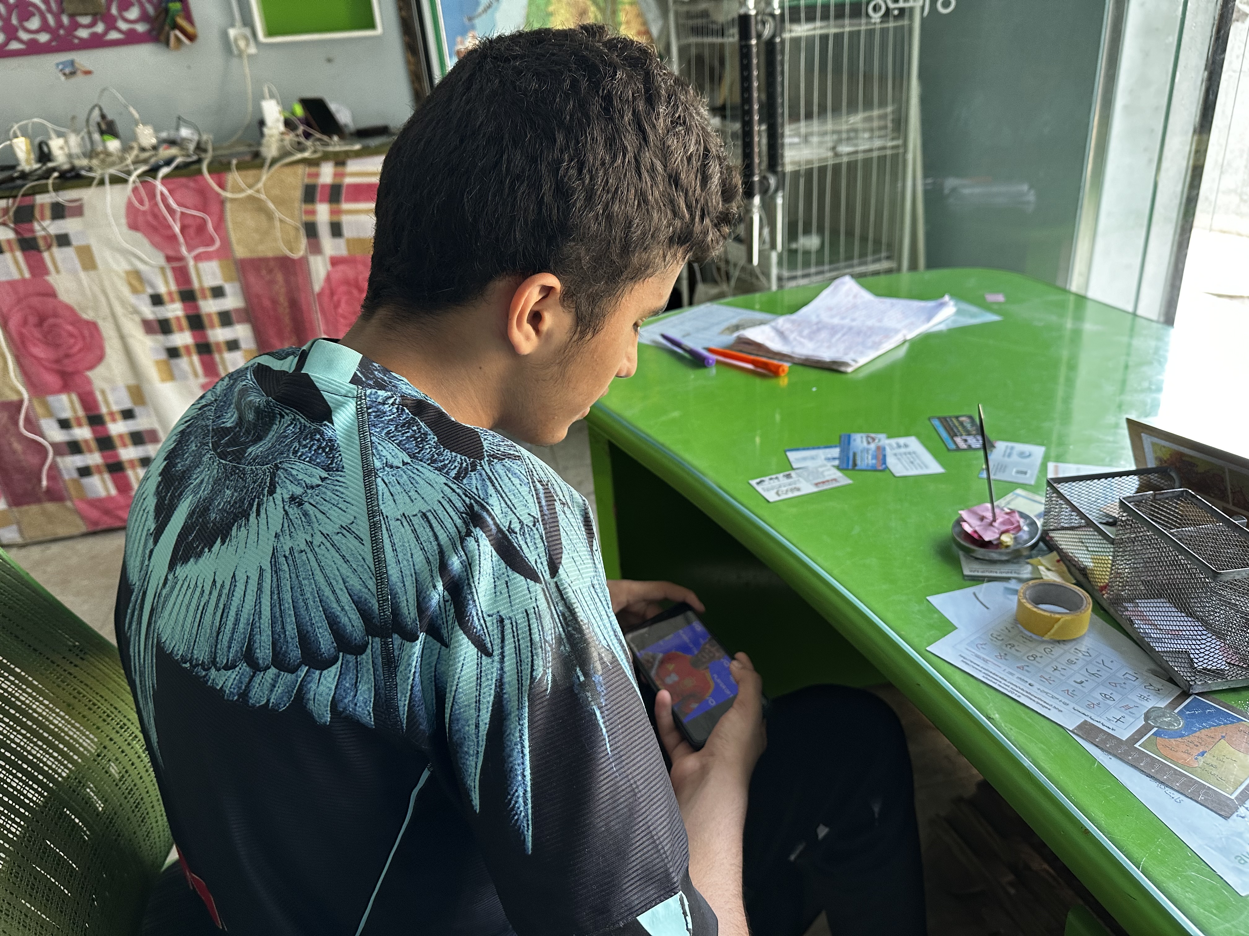 A Palestinian child in Gaza charges his mobile phone in order to follow the Euro 2024 football championship [Abubaker Abed/Al Jazeera]