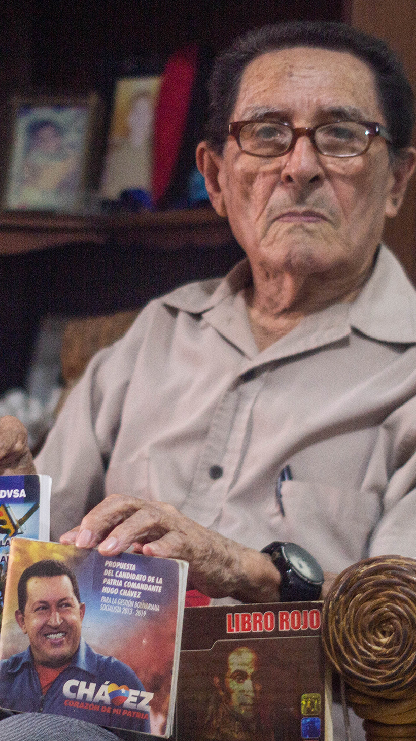 Luis Bermudez shows off his pro-Chavez and pro-Maduro booklets