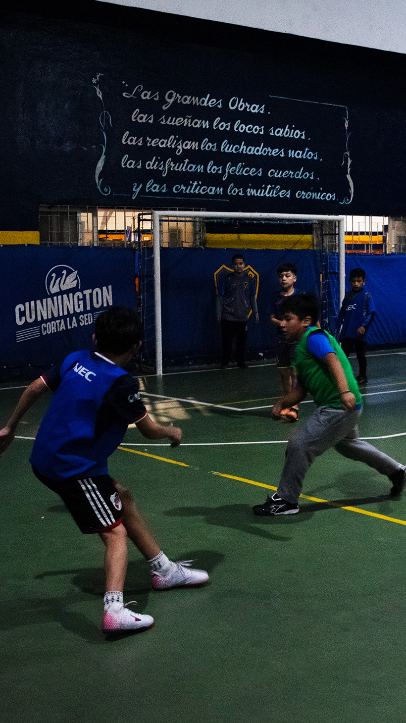 Boys in Argentina play soccer on an indoor field.