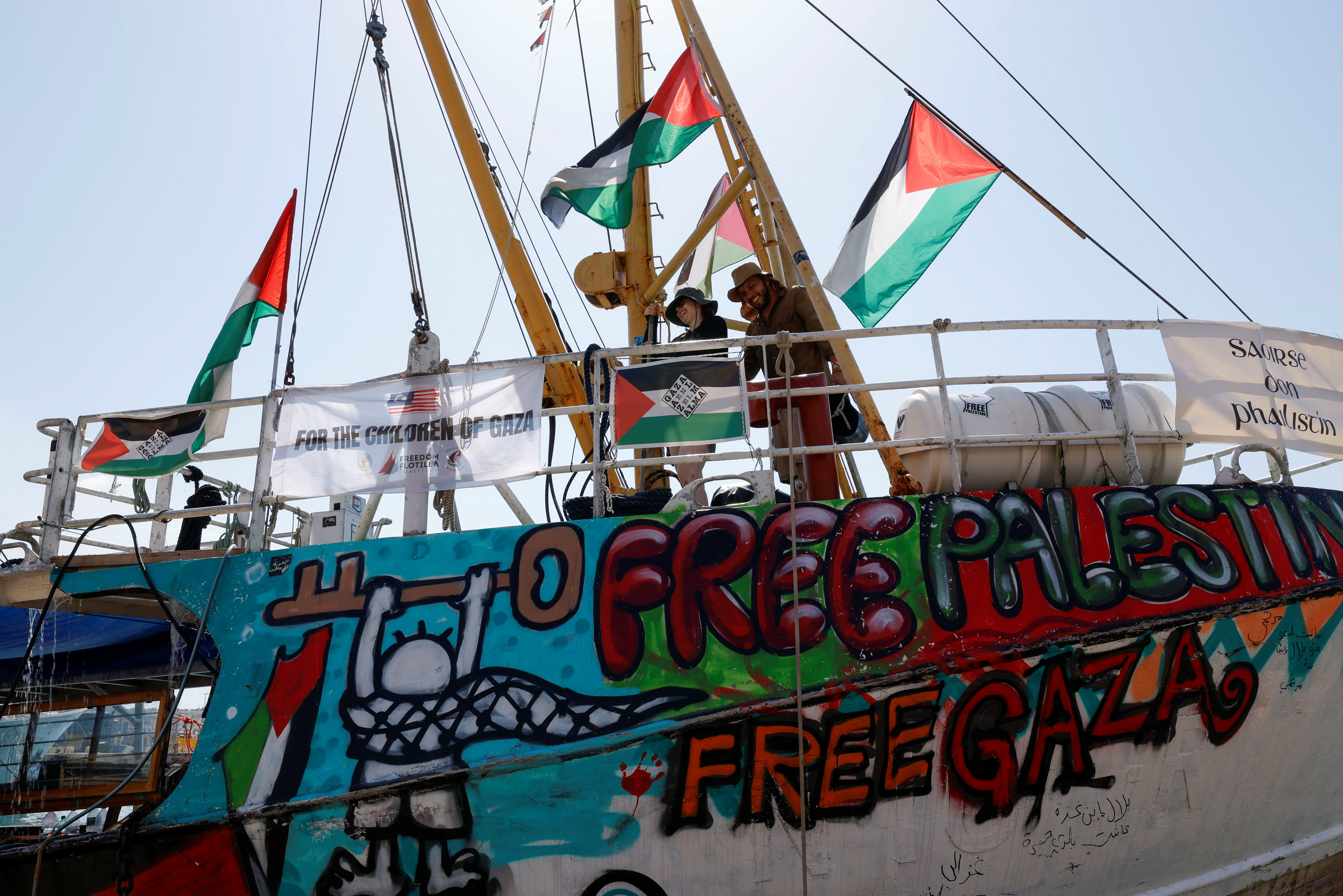 Activists wash the deck of the Freedom Flotilla Coalition ship 'Handala' as they prepare to sail for Gaza