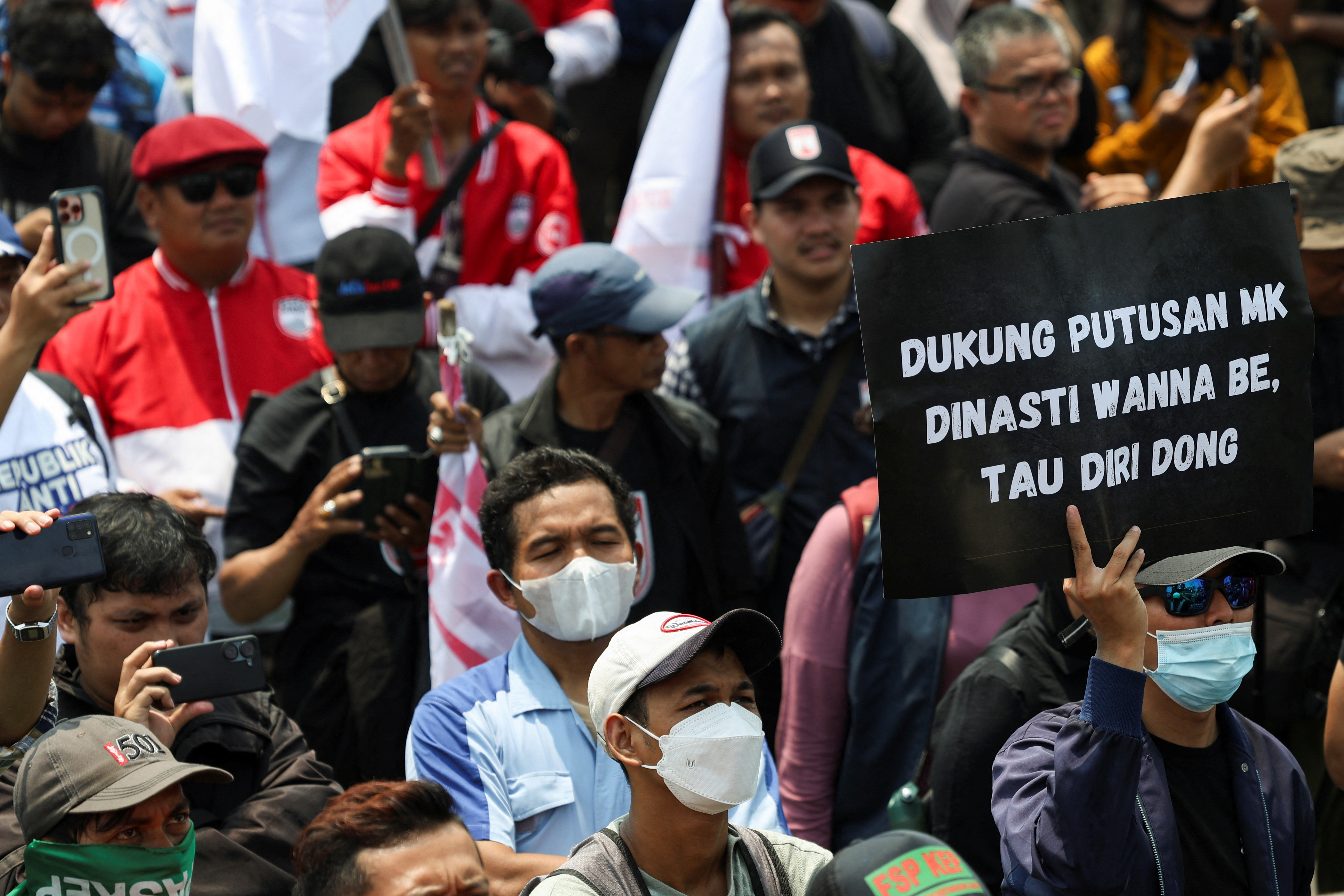 People attend a protest outside the Indonesian Parliament against the revisions to the country's election law