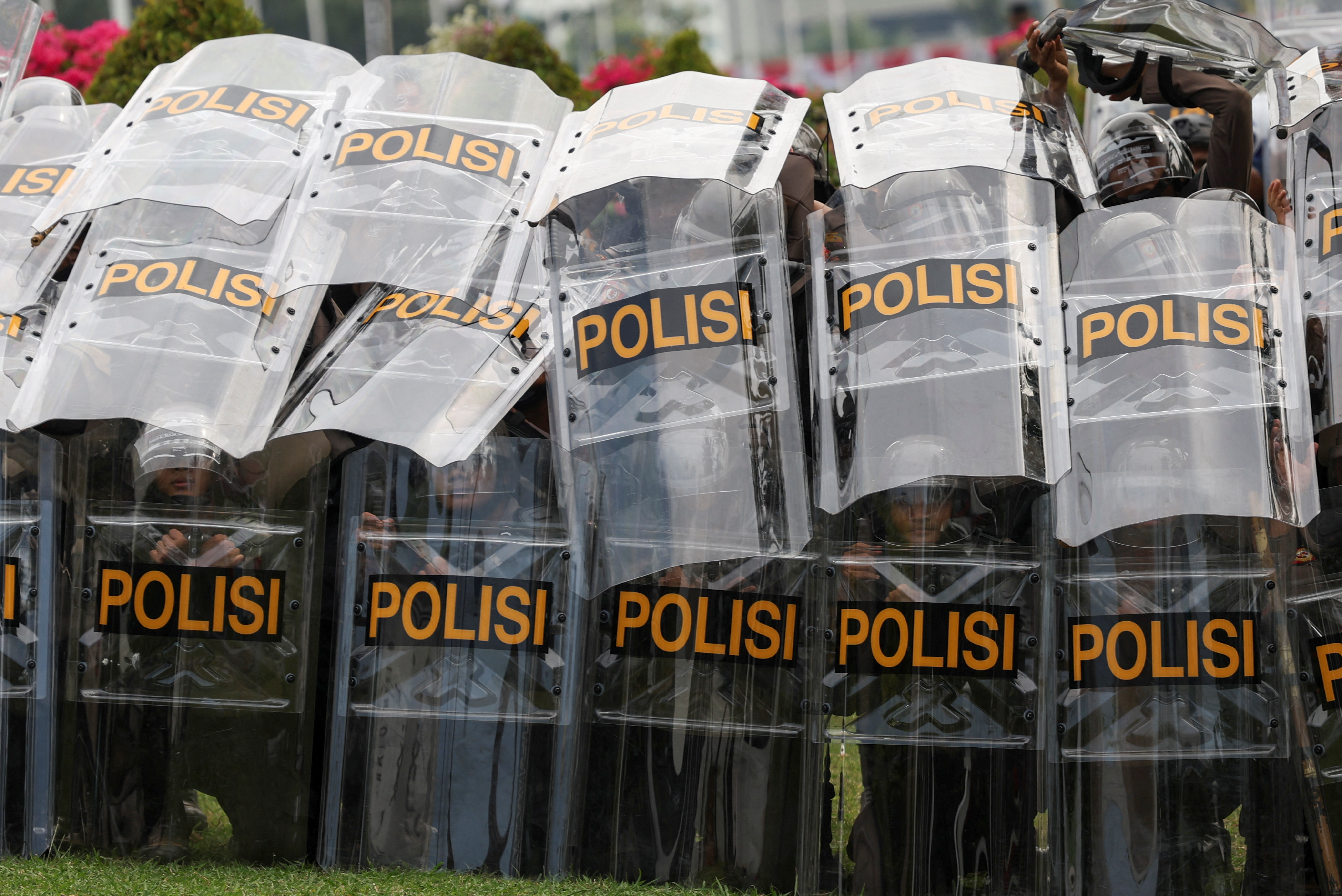 People attend a protest outside the Indonesian Parliament against the revisions to the country's election law