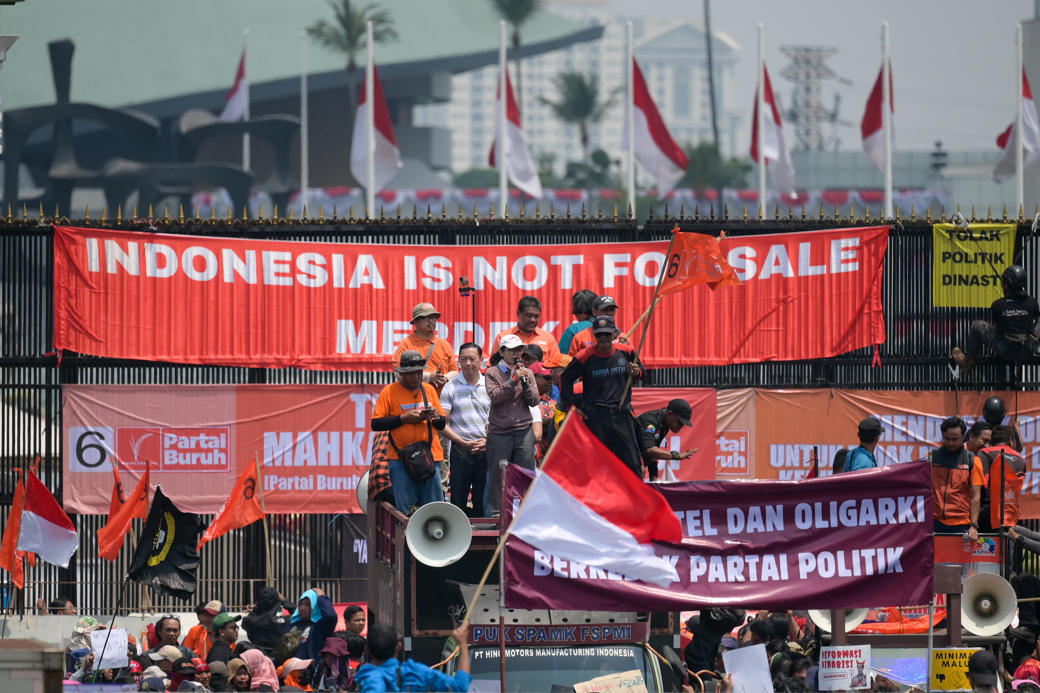 People attend a protest outside the Indonesian Parliament against the revisions to the country's election law