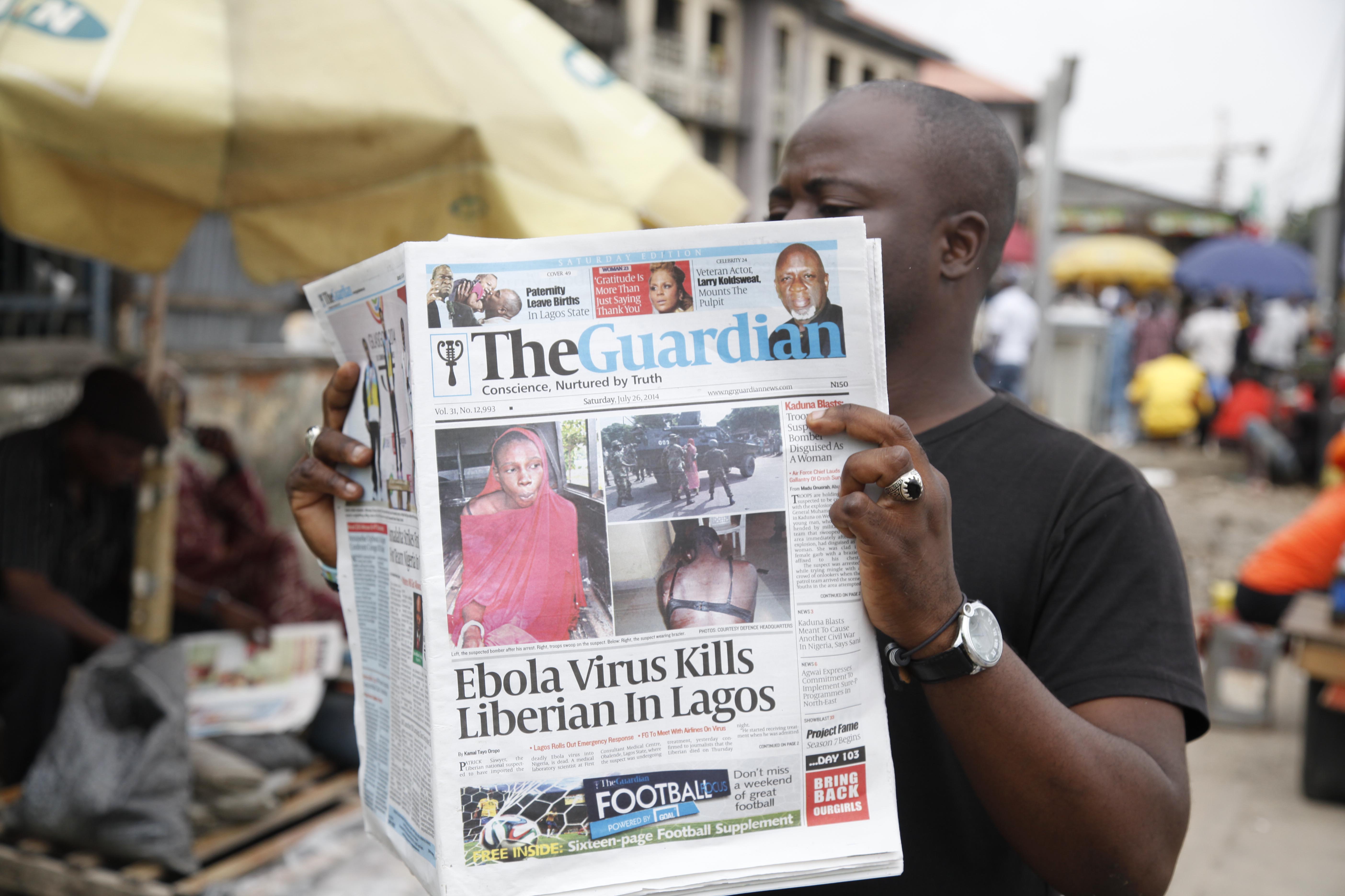 Man reads newspaper on Ebola in Lagos