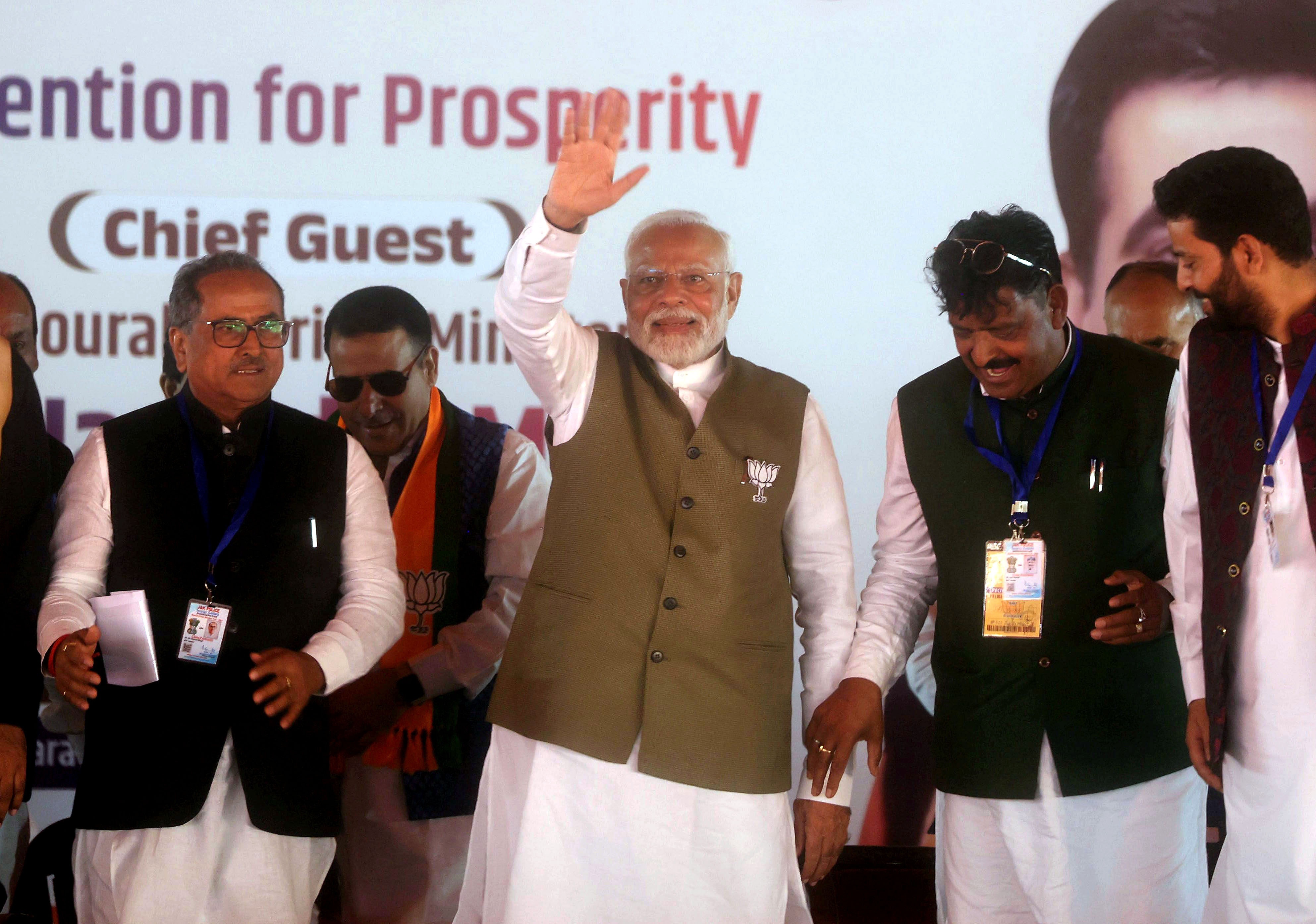 Indian Prime Minister Narendra Modi (C) waves to the crowd as he arrives to address an election rally at Sher-e-Kashmir Stadium in Srinagar, India