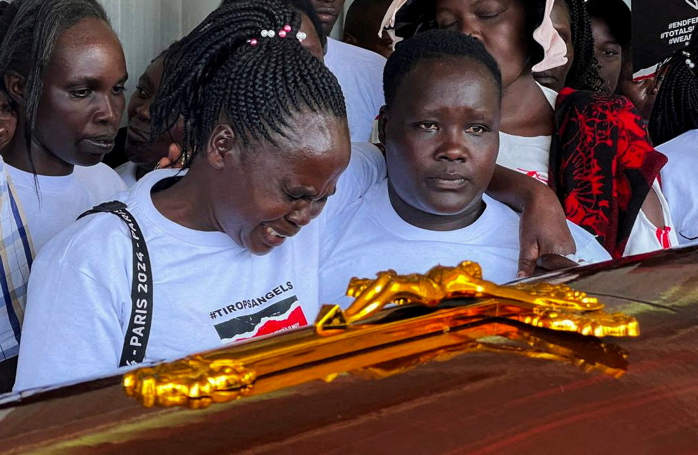 Agnes Cheptegei mourns next to the coffin of her Olympian daughter