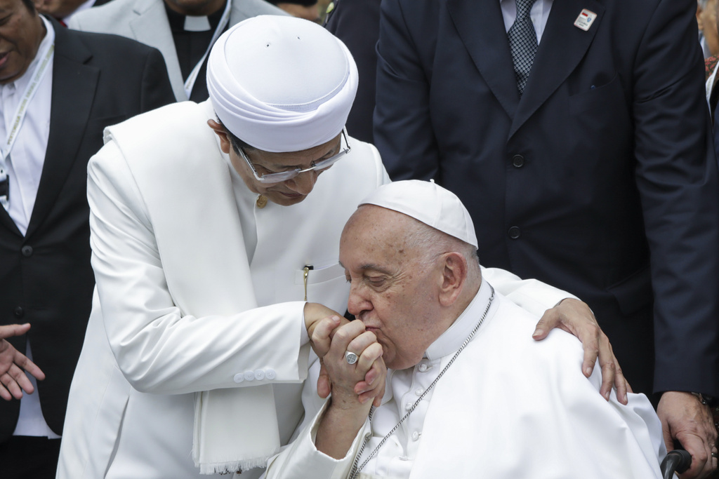 Pope Francis, right, kisses the right hand of the Grand Imam of Istiqlal Mosque Nasaruddin Umar