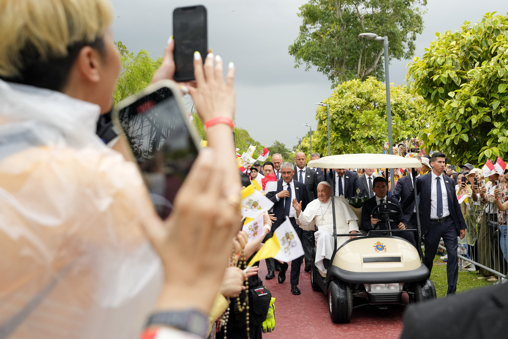 Pope Francis travels in a buggy as he greets volunteers on his arrival in Singapore on Wednesday