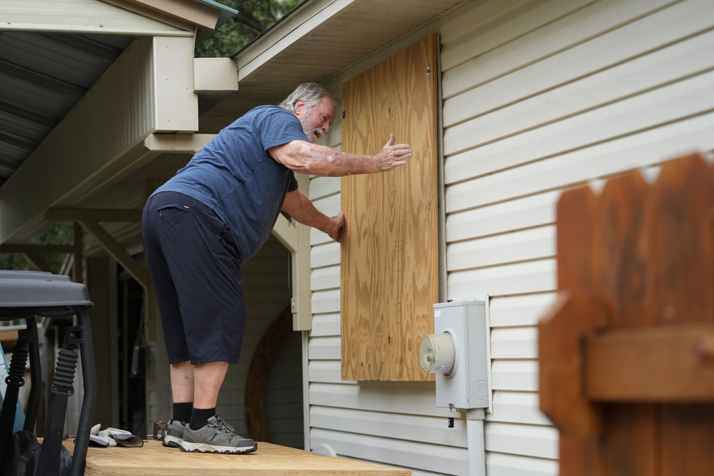 A man boards up the windows to his home in advance of Tropical Storm Helene, expected to make landfall as a hurricane, in Ochlockonee Bay, Fla., Wednesday, September. 25, 2024. [Gerald Herbert/AP]