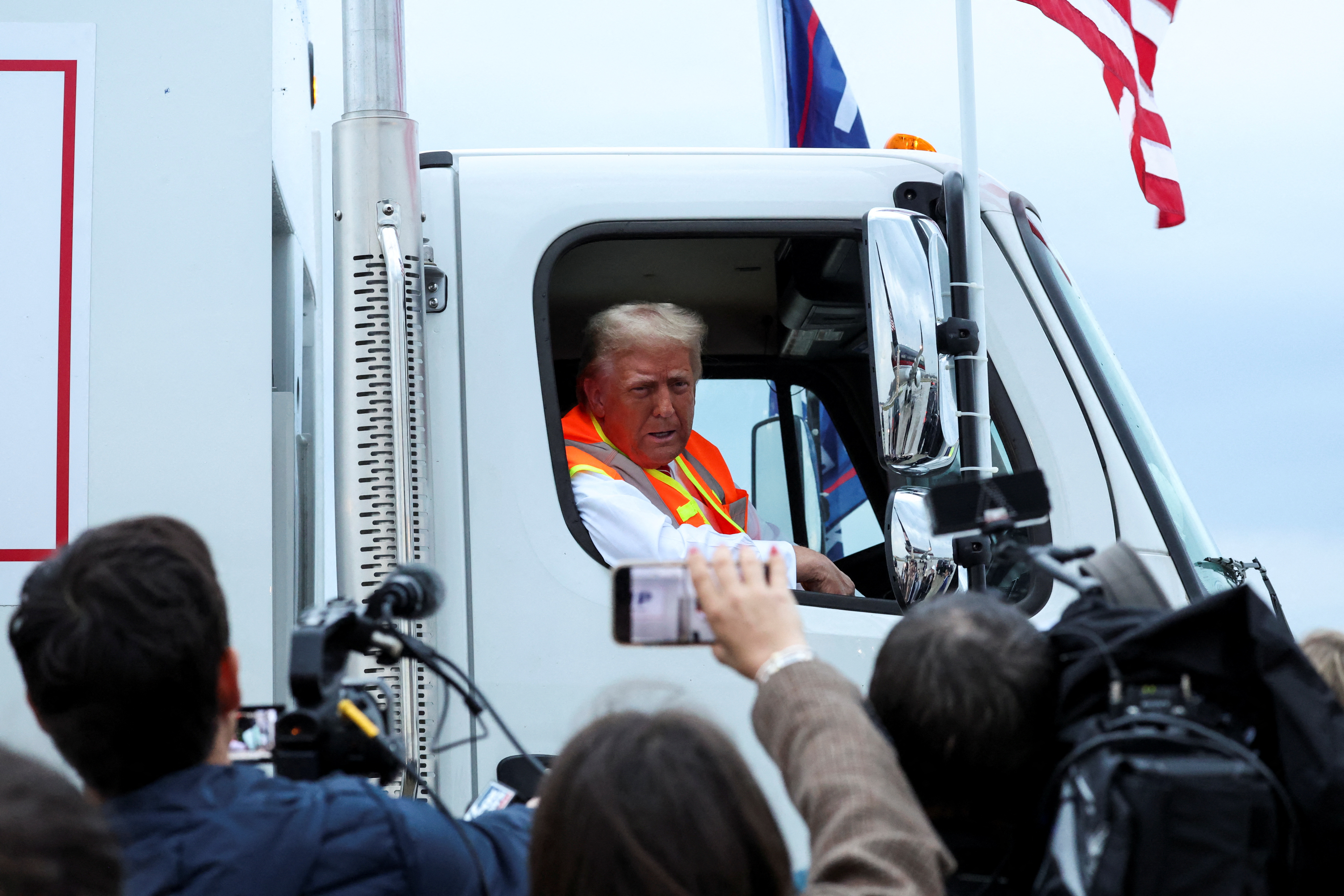 Republican presidential nominee and former U.S. President Donald Trump speaks to the members of the media, as he sits in a garbage truck, in Green Bay