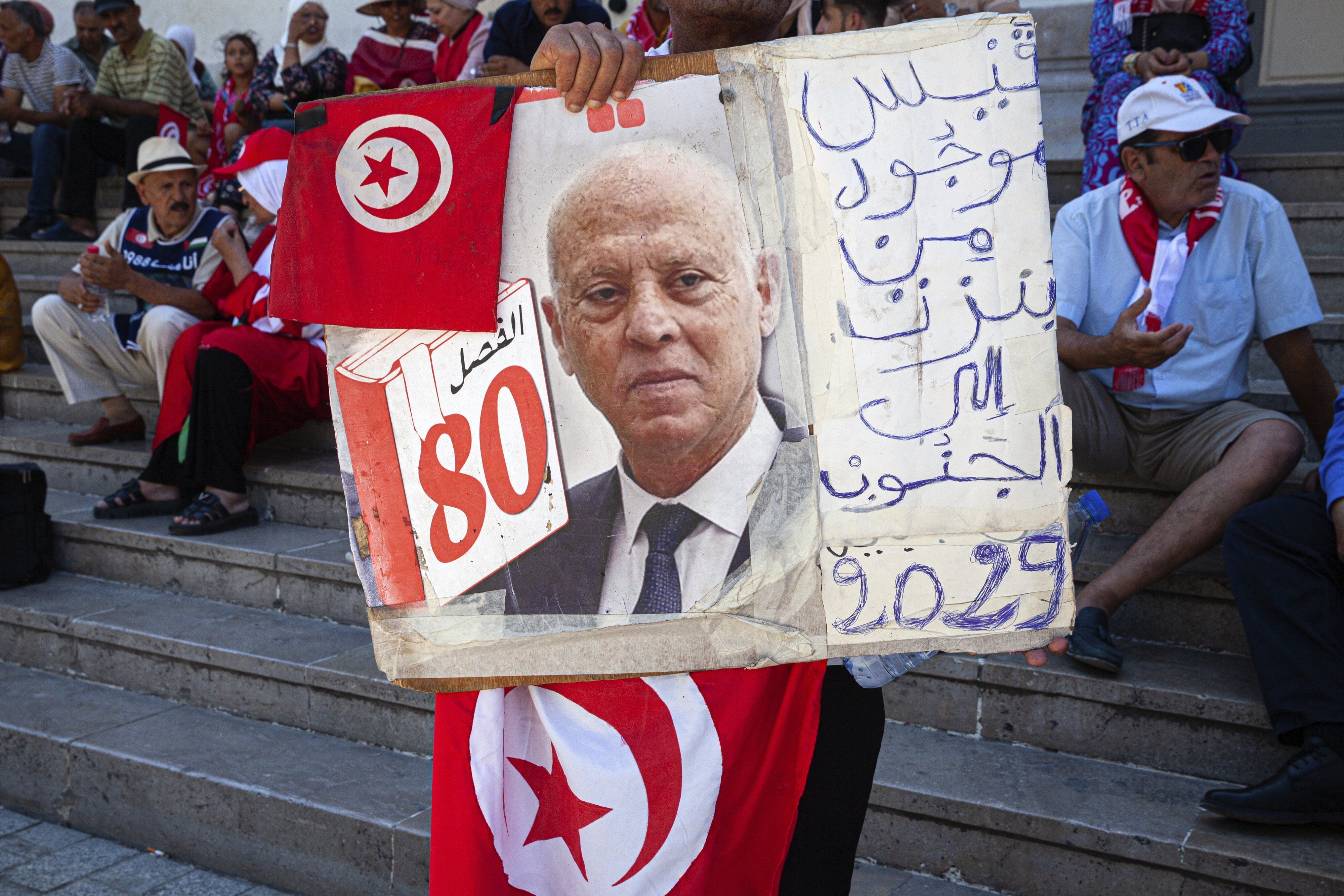 A supporter of Tunisian President Kais Saied holds up his image.