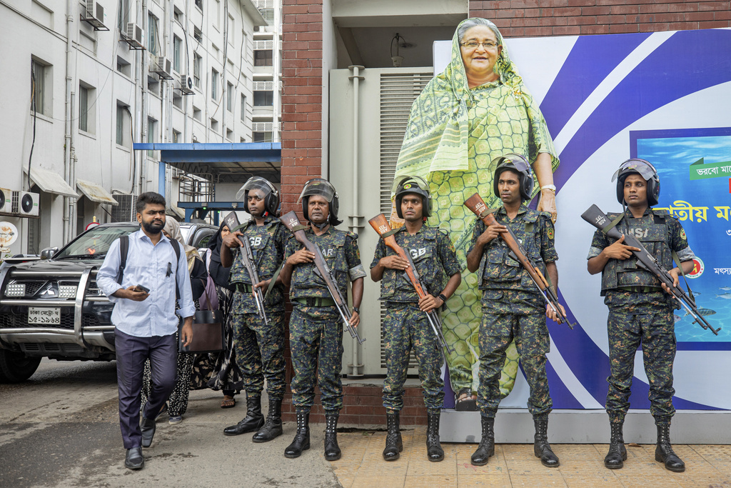 Military personnel stand in front of a portrait of Prime Minister Sheikh Hasina in Dhaka, Bangladesh, on July 30, 2024