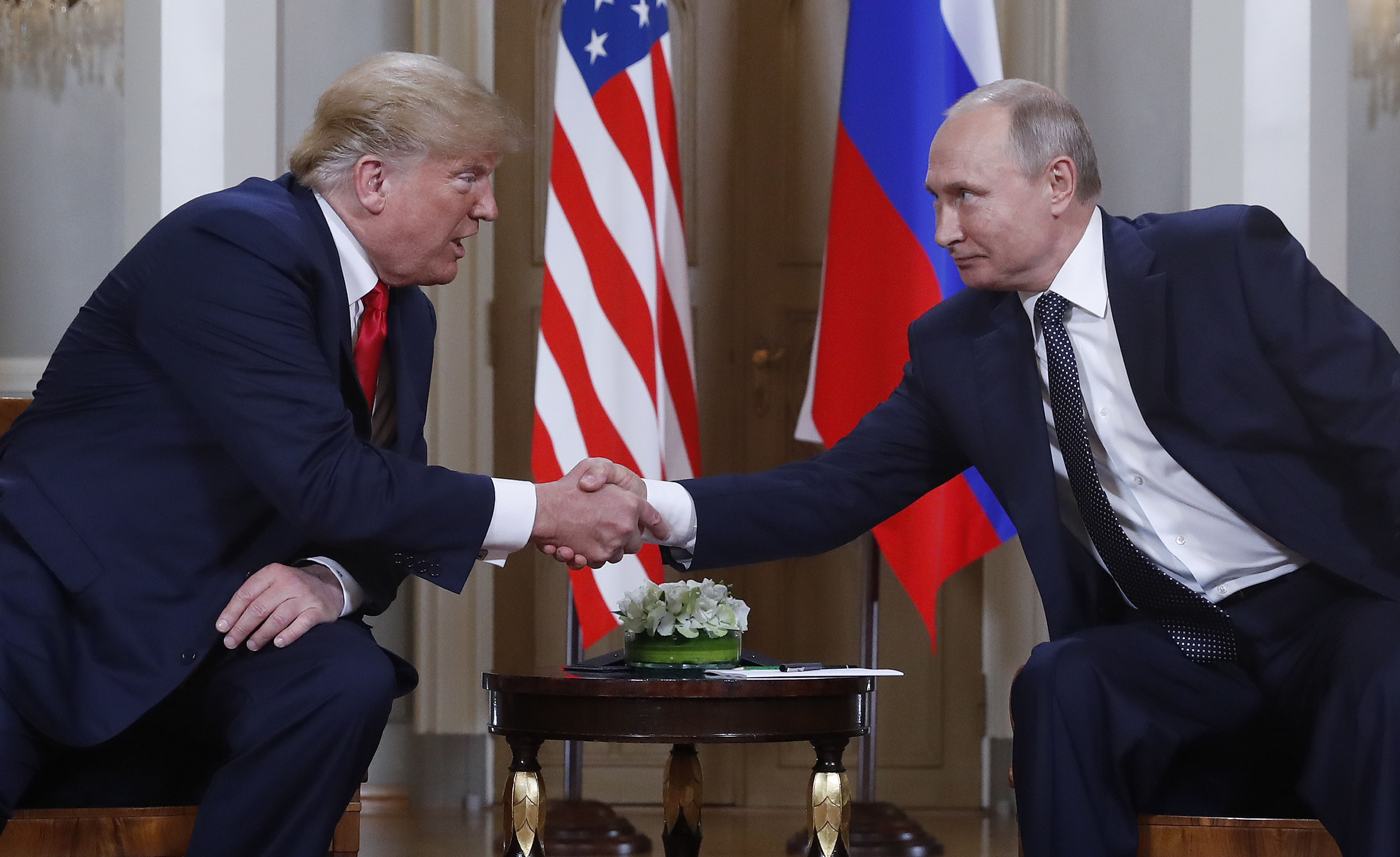 US President Donald Trump, left, and Russian President Vladimir Putin, right, shake hands at the beginning of a meeting at the Presidential Palace in Helsinki, Finland, July 16, 2018.