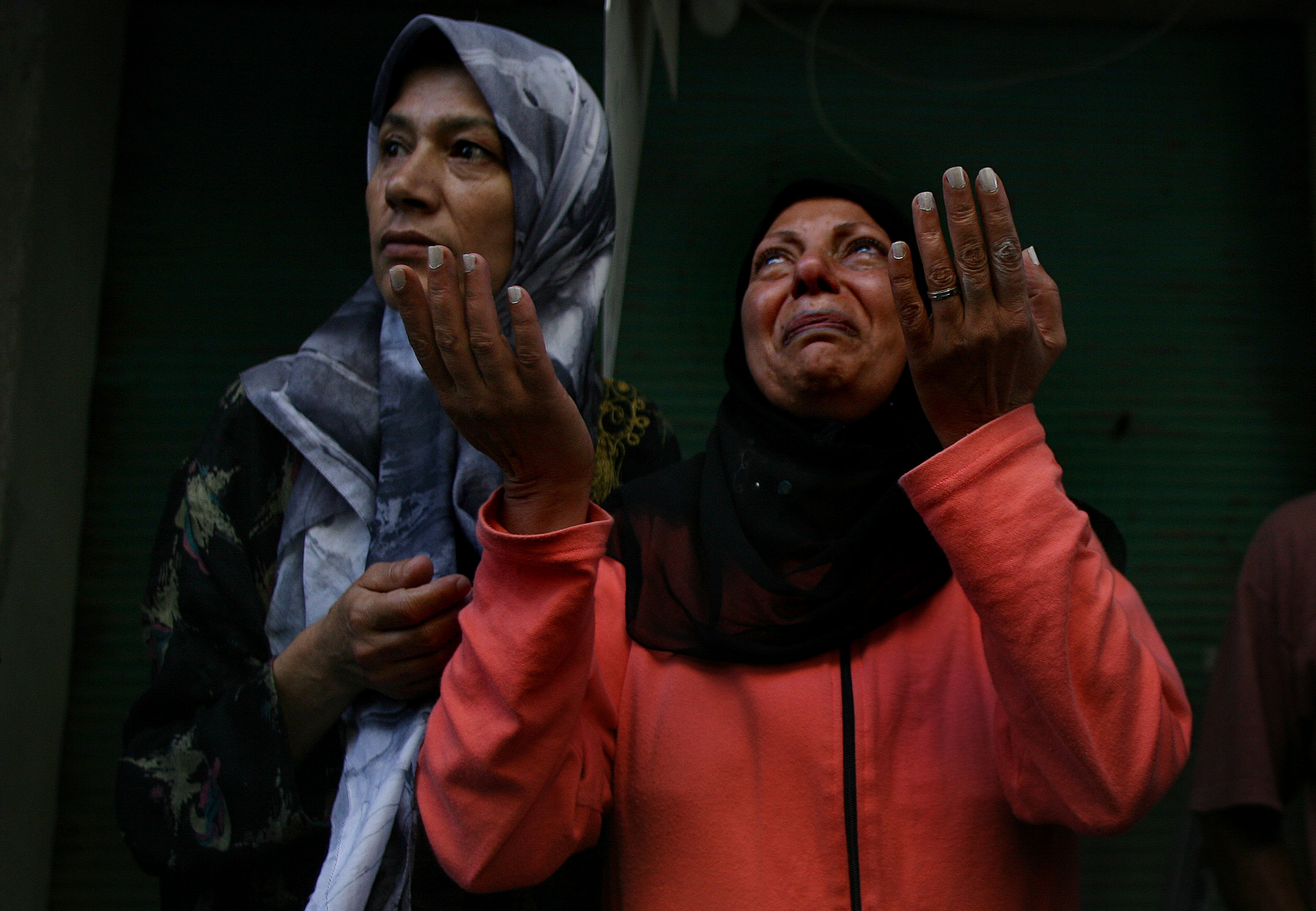 Lebanon 2006. At the Shayyah bomb site Mayah Yatim, right, raises her hands as she grieves for her 25 year old 8 month pregnant daughter and 4year old grandson killed when their building collapsed after Israeli strikes targeted the southern suburb of Shayyh in Beirut. Rescuers continued searching for survivors and the dead amongst the rubble where already 15 have been killed and 65 injured, 8 August 2006
