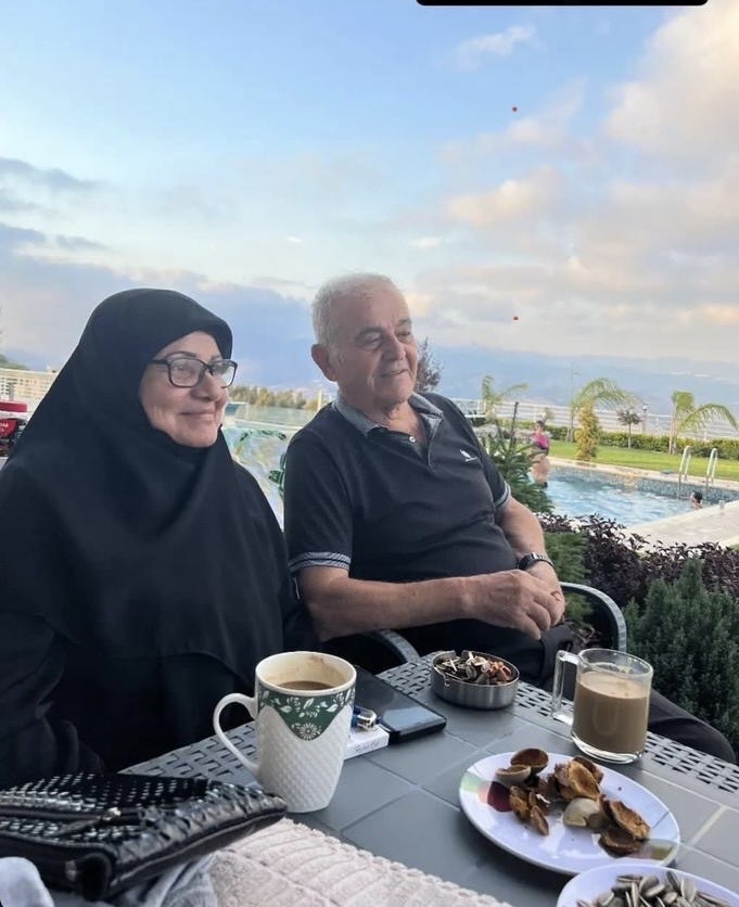Couple seen as they drink coffee by a pool