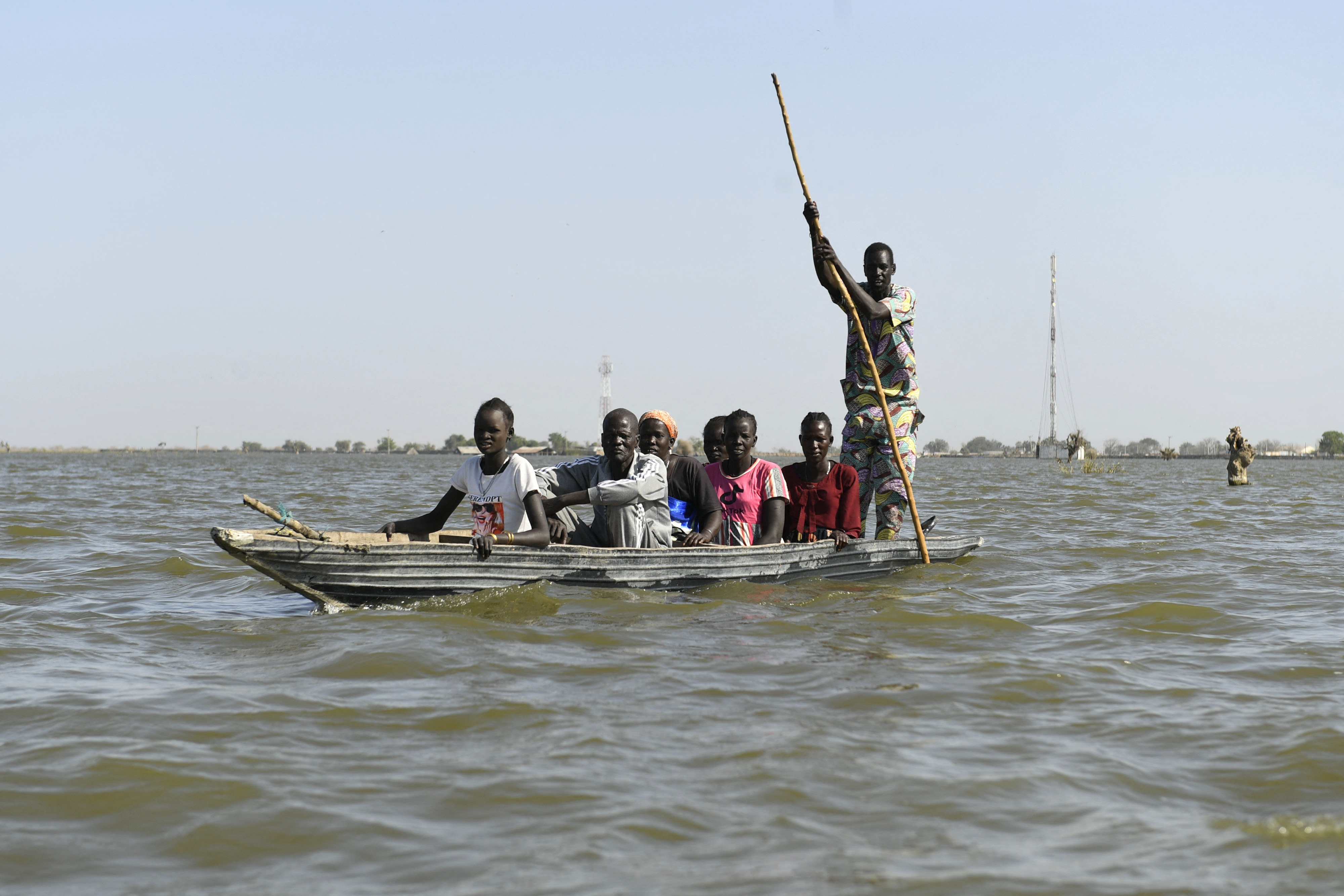 Internally displaced people use a boat to cross water