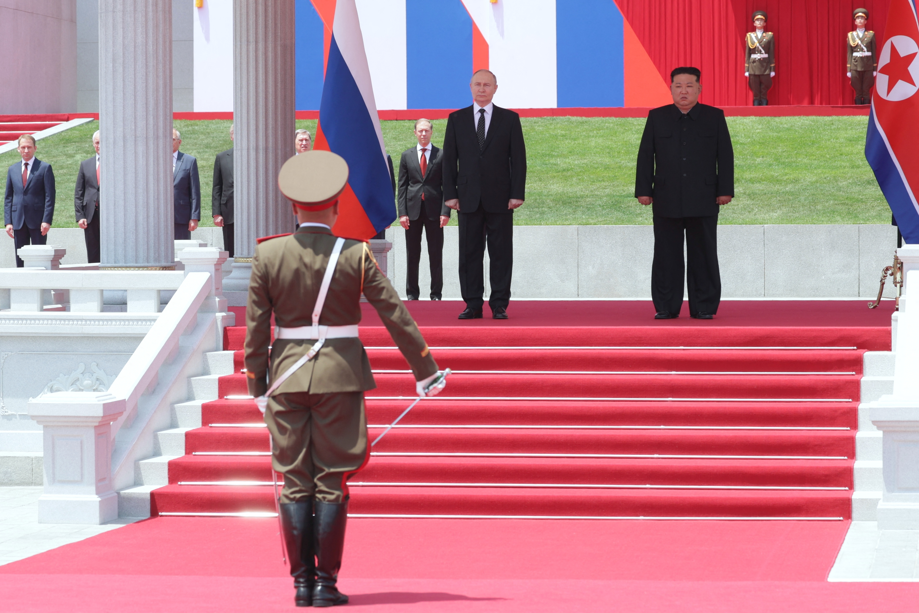 In this pool photograph distributed by the Russian state agency Sputnik, North Korea's leader Kim Jong Un (R) and Russian President Vladimir Putin attend a welcoming ceremony at Kim Il Sung Square in Pyongyang on June 19, 2024. Russian President Vladimir Putin landed in North Korea early on June 19, the Kremlin said, kicking off a visit set to boost defence ties between the two nuclear-armed countries as Moscow pursues its war in Ukraine. (Photo by Gavriil GRIGOROV / POOL / AFP) / -- EDITOR'S NOTE : THIS IMAGE IS DISTRIBUTED BY THE RUSSIAN STATE OWNED AGENCY SPUTNIK --
