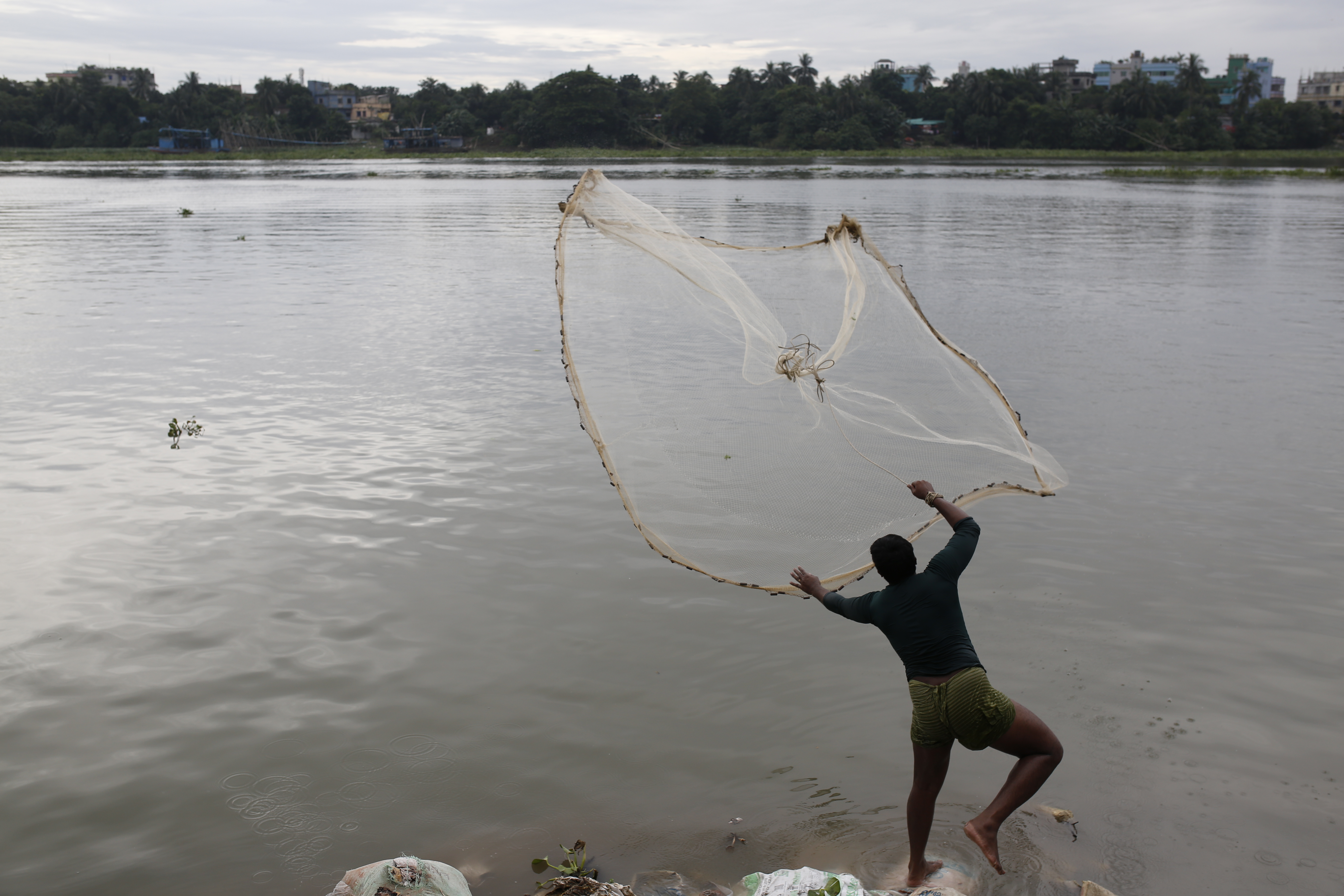 A man casts his fishing net into the Buriganga River in Dhaka, Bangladesh, on October 23, 2024. Rivers in the country were awarded legal rights as ‘living entities’ in 2019