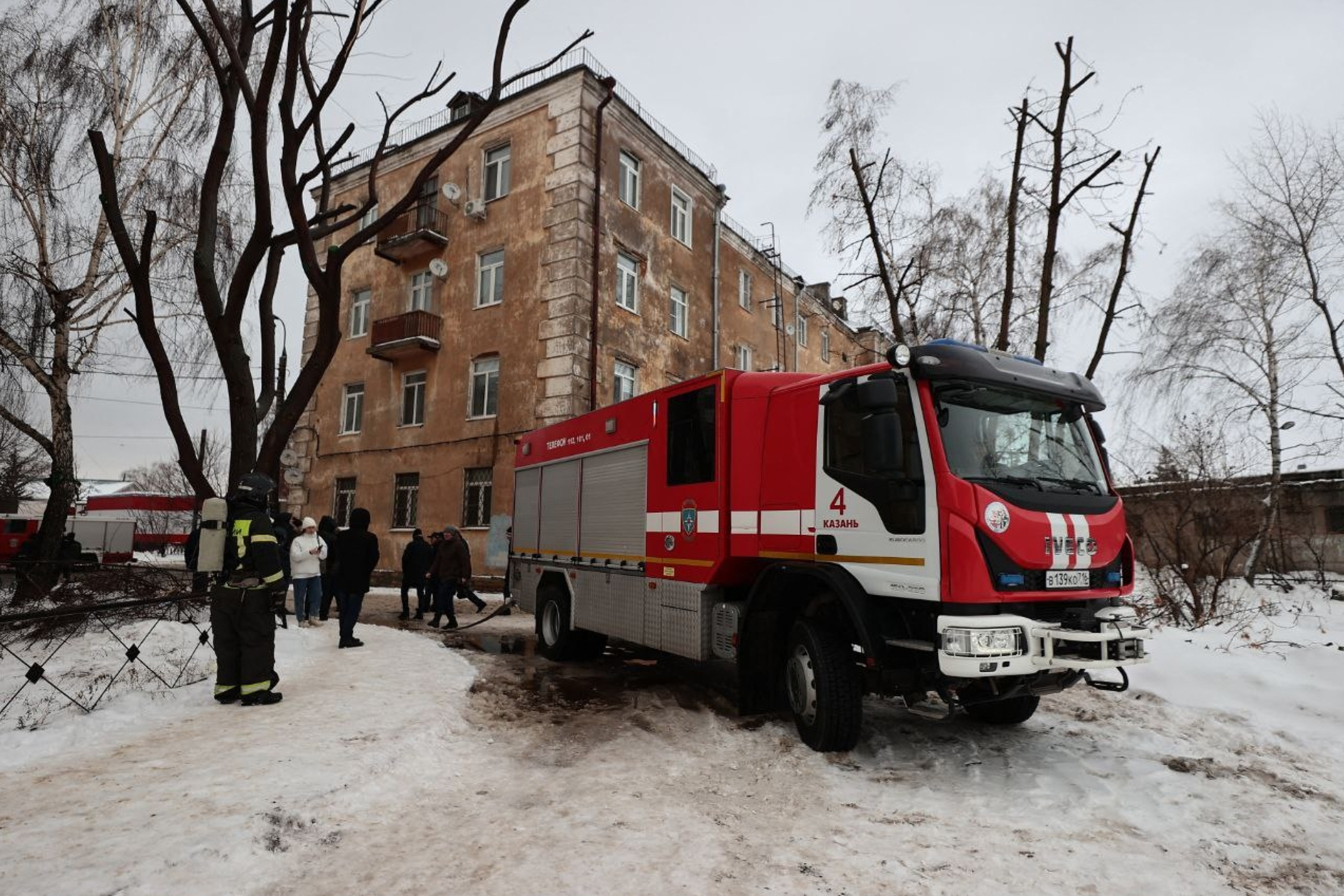 In this handout photograph taken and released on the official Telegram account of the Mayor's Office of Kazan on December 21, 2024, a Russian rescuer works in the courtyard of a residential building following a drone attack in Kazan