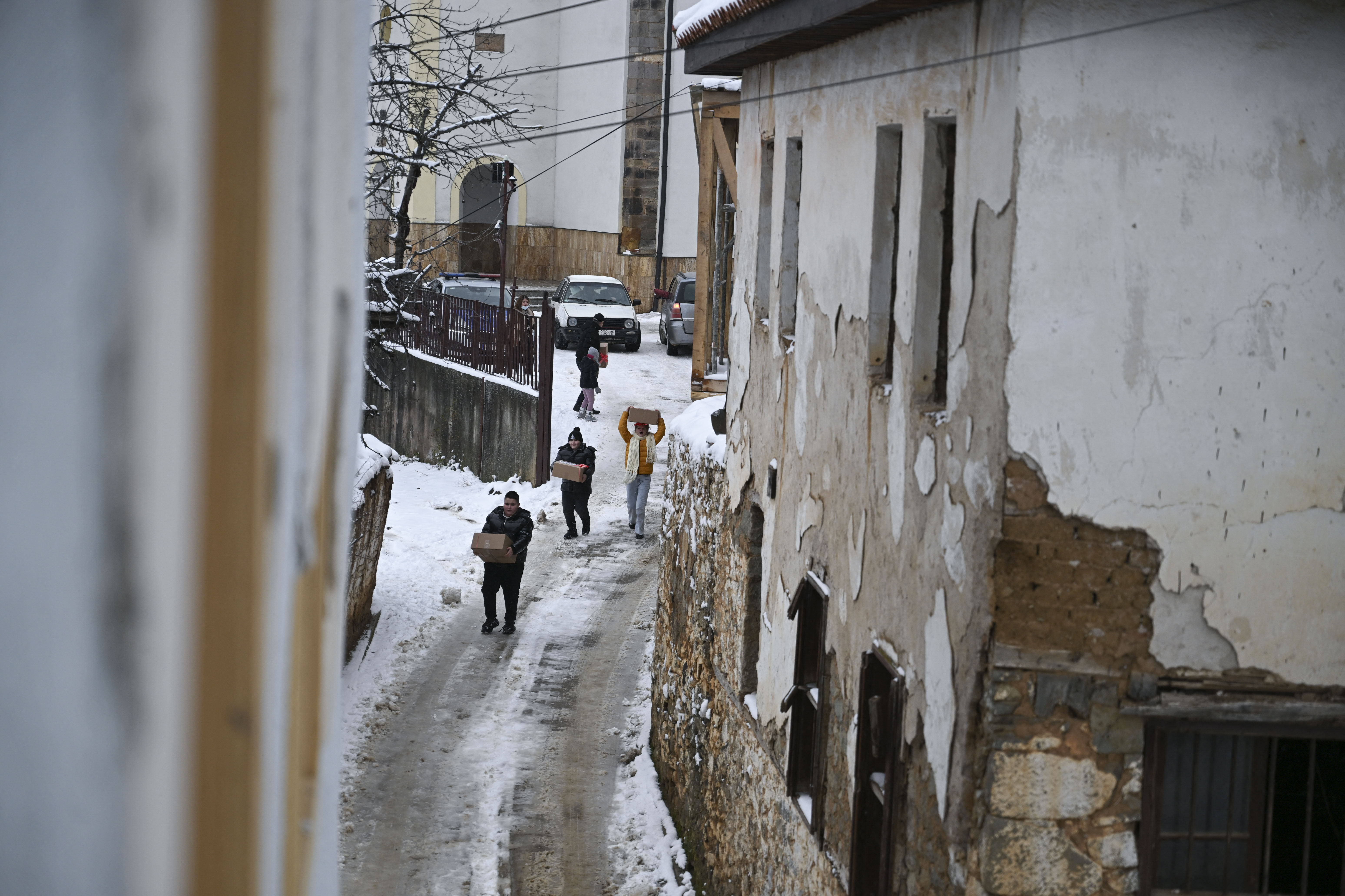 Christian faithful holds gifts as they leave the Saint Nicholas church after attending a Christmas mass in the small town of Janjeve, Kosovo, during Christmas celebrations on December 25