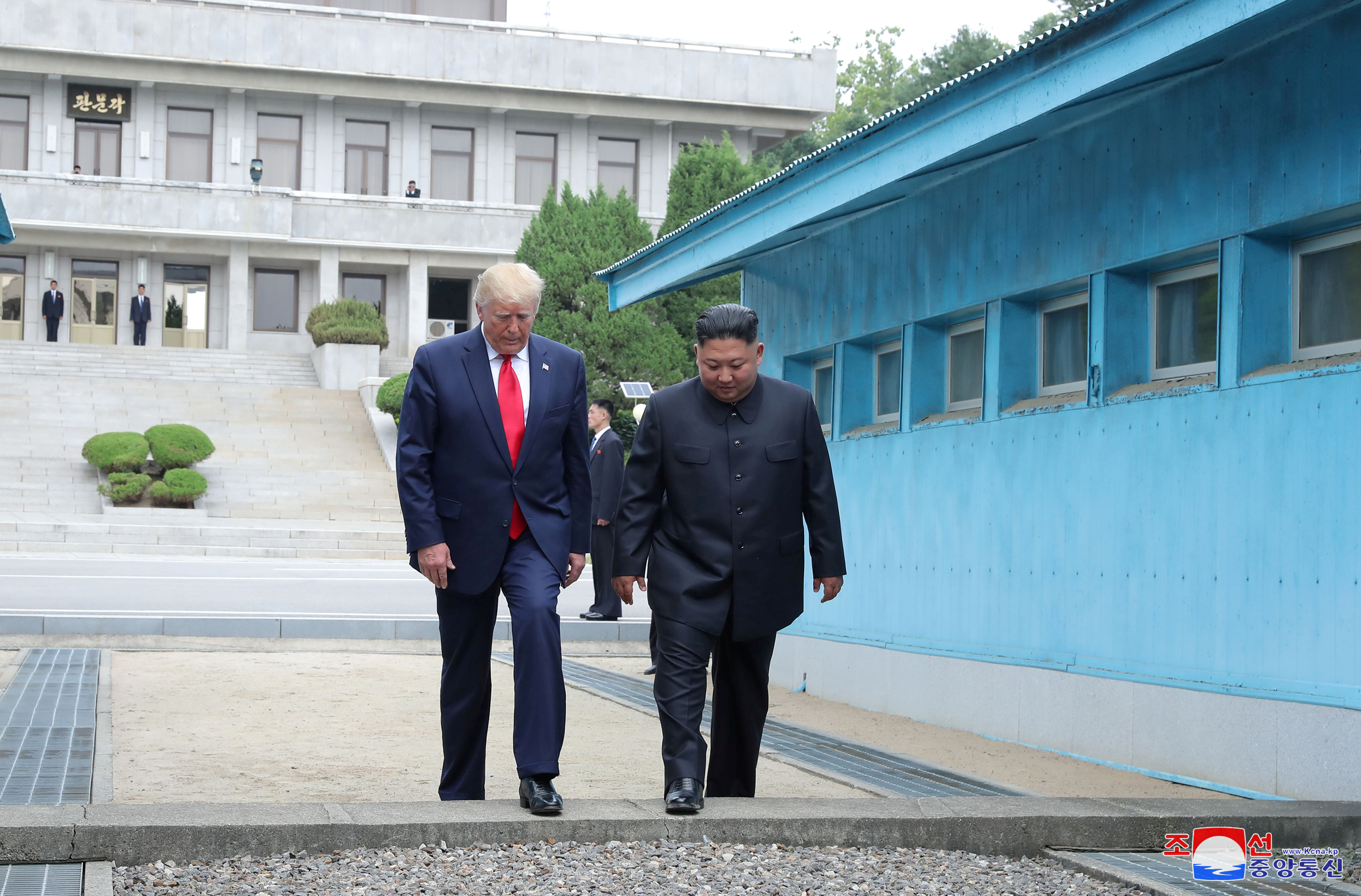 U.S. President Donald Trump and North Korean leader Kim Jong Un cross over a military demarcation line at the demilitarized zone (DMZ) separating the two Koreas, in Panmunjom, South Korea, June 30, 2019. KCNA via REUTERS