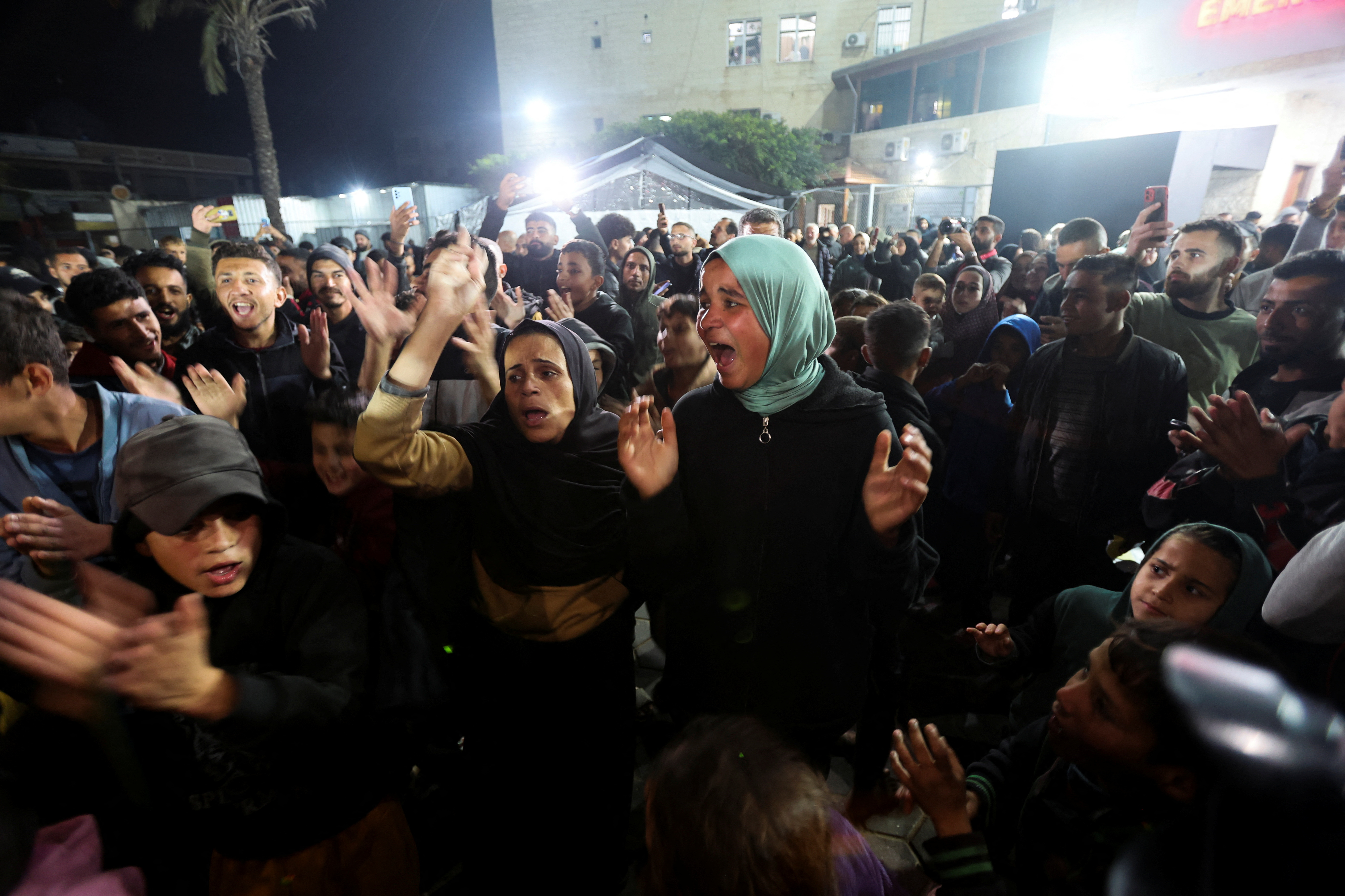Palestinians react to news on a ceasefire deal with Israel, in Deir Al-Balah