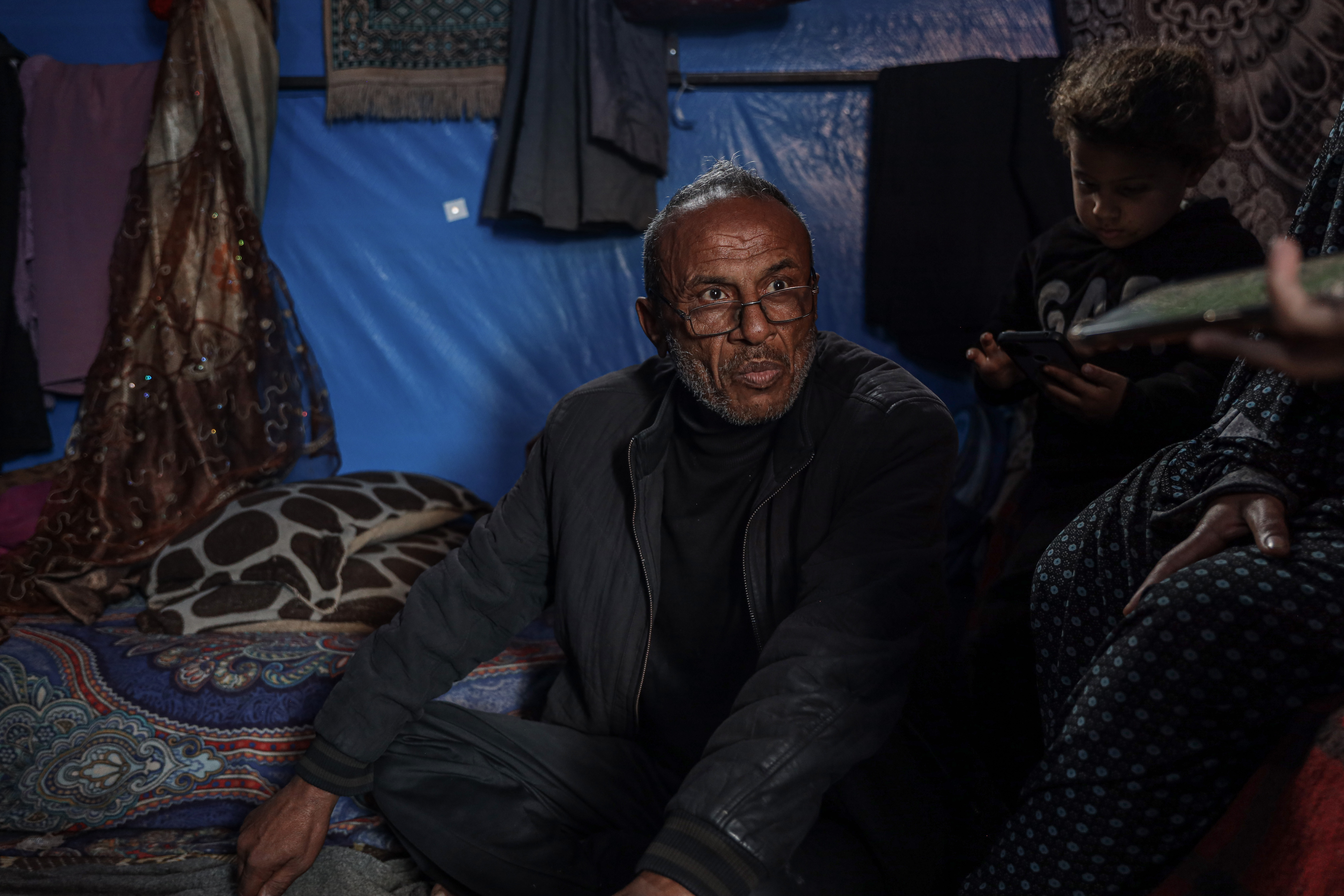 Nahid sits cross-legged on the flooe