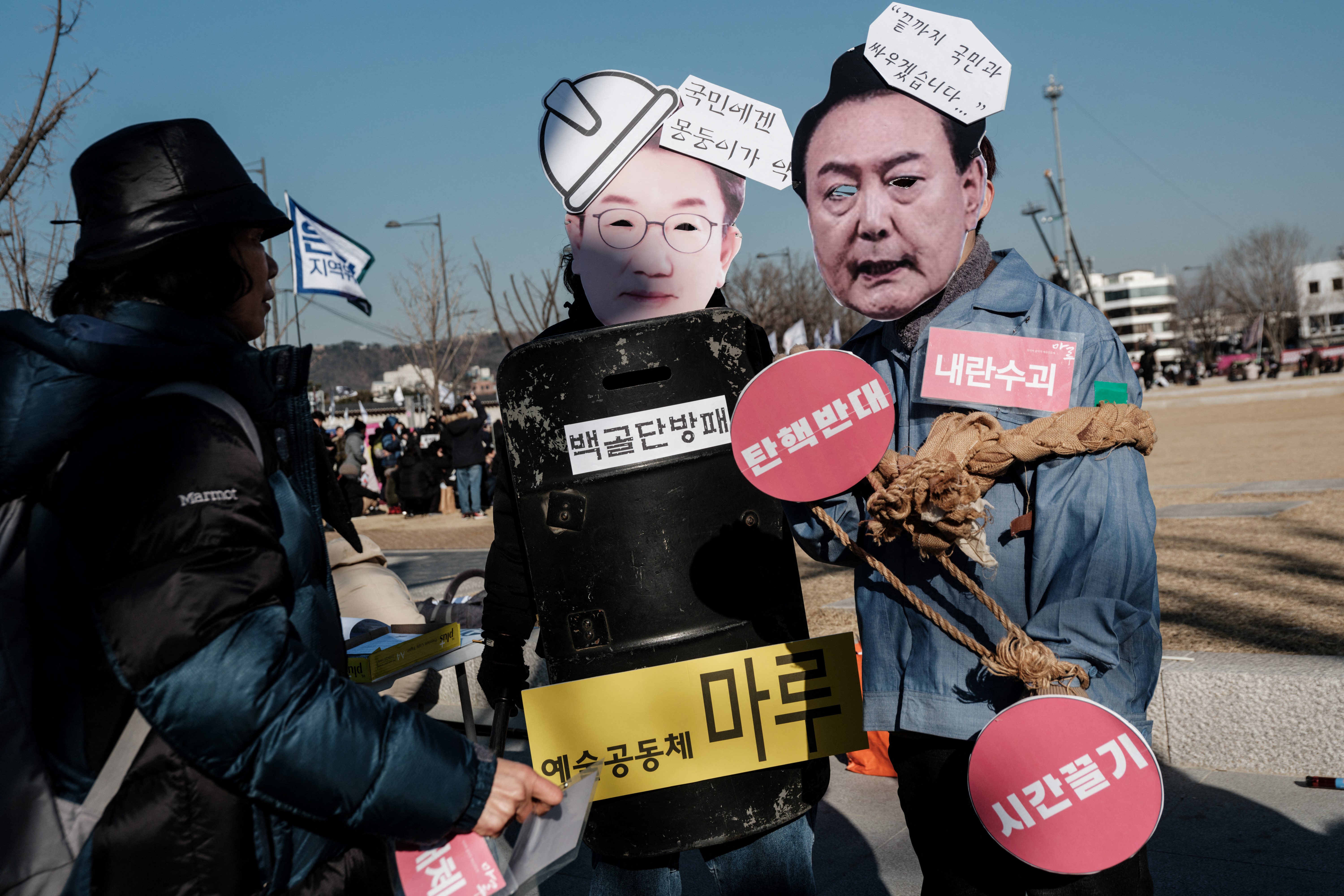 Protesters wear masks before a rally against impeached South Korean President Yoon Suk Yeol in Seoul on January 11, 2025. (Photo by YASUYOSHI CHIBA / AFP)