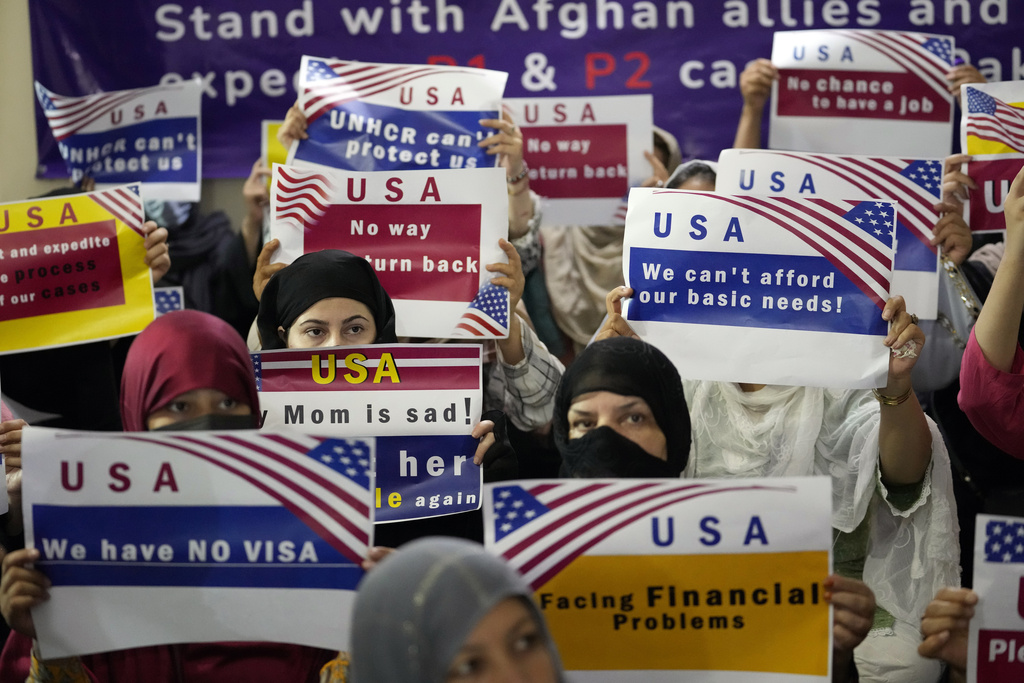 Afghan refugees in Pakistan hold placards protesting their condition