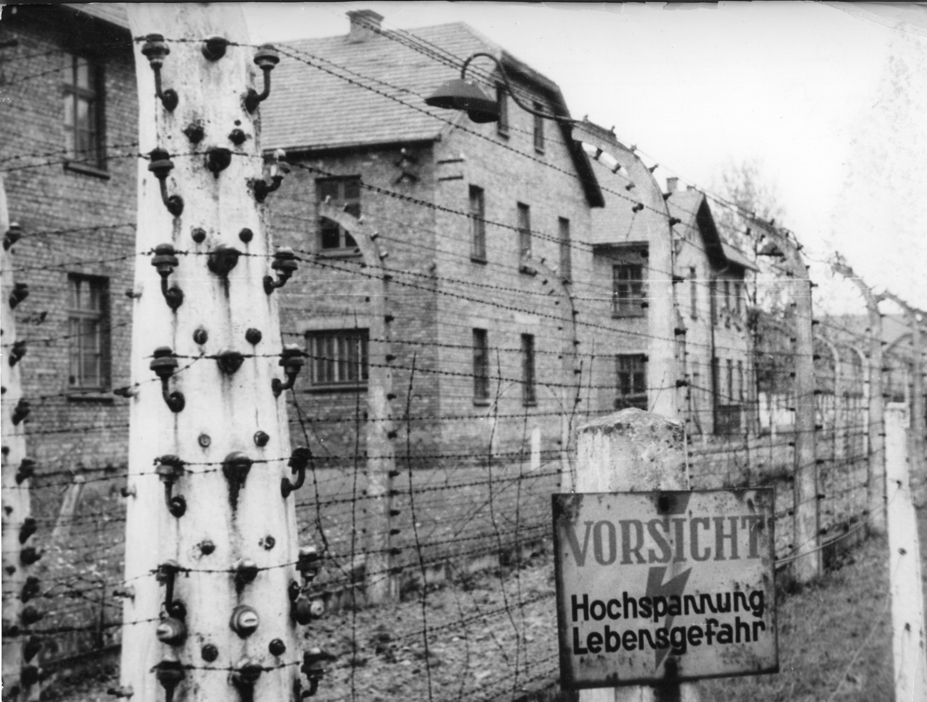 This June 1958 image shows buildings behind a defunct high-voltage electric fence of the Nazi concentration camp Auschwitz I, Poland, which was liberated by the Soviets in January 1945