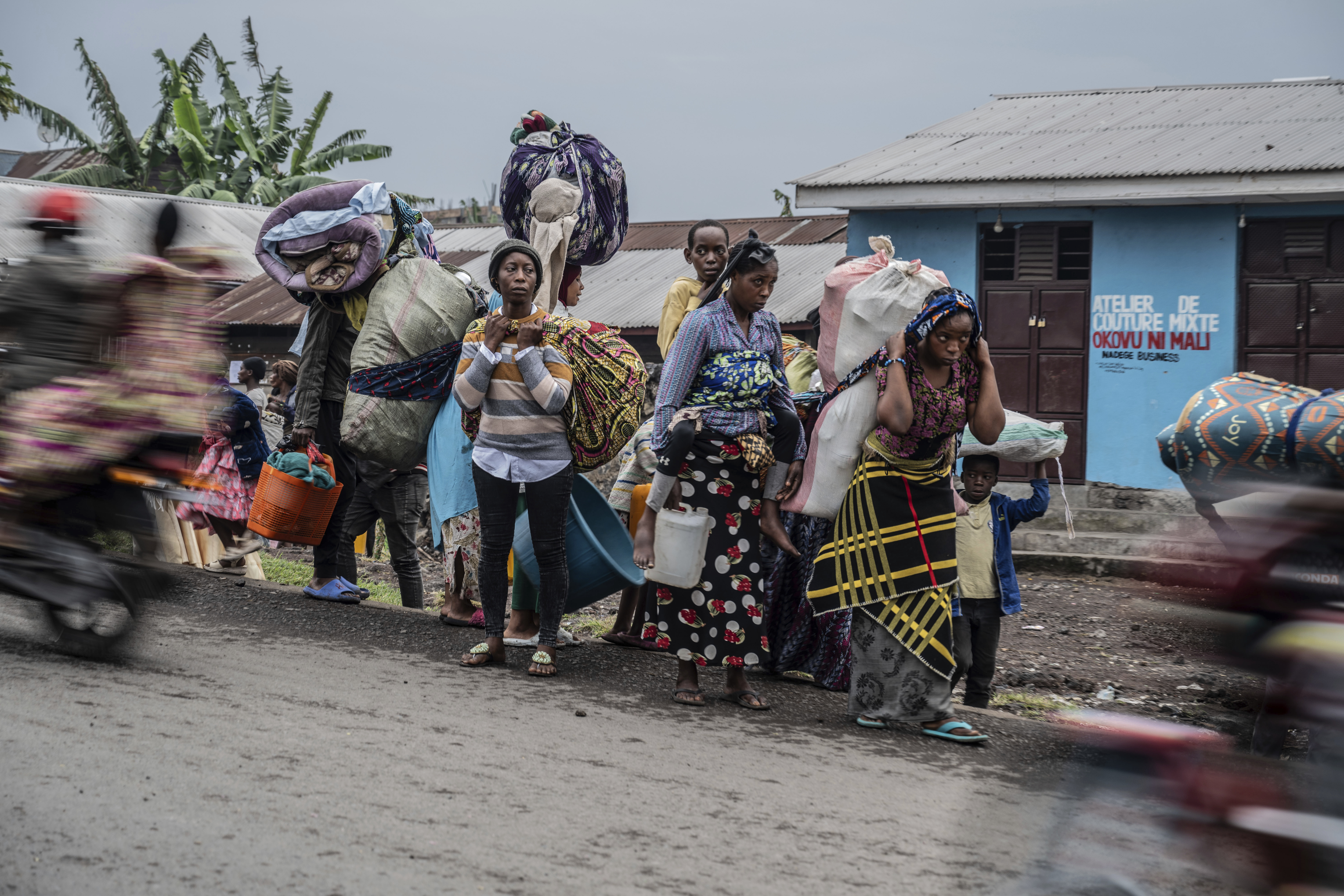 People displaced by the fighting with M23 rebels make their way to the centre of Goma