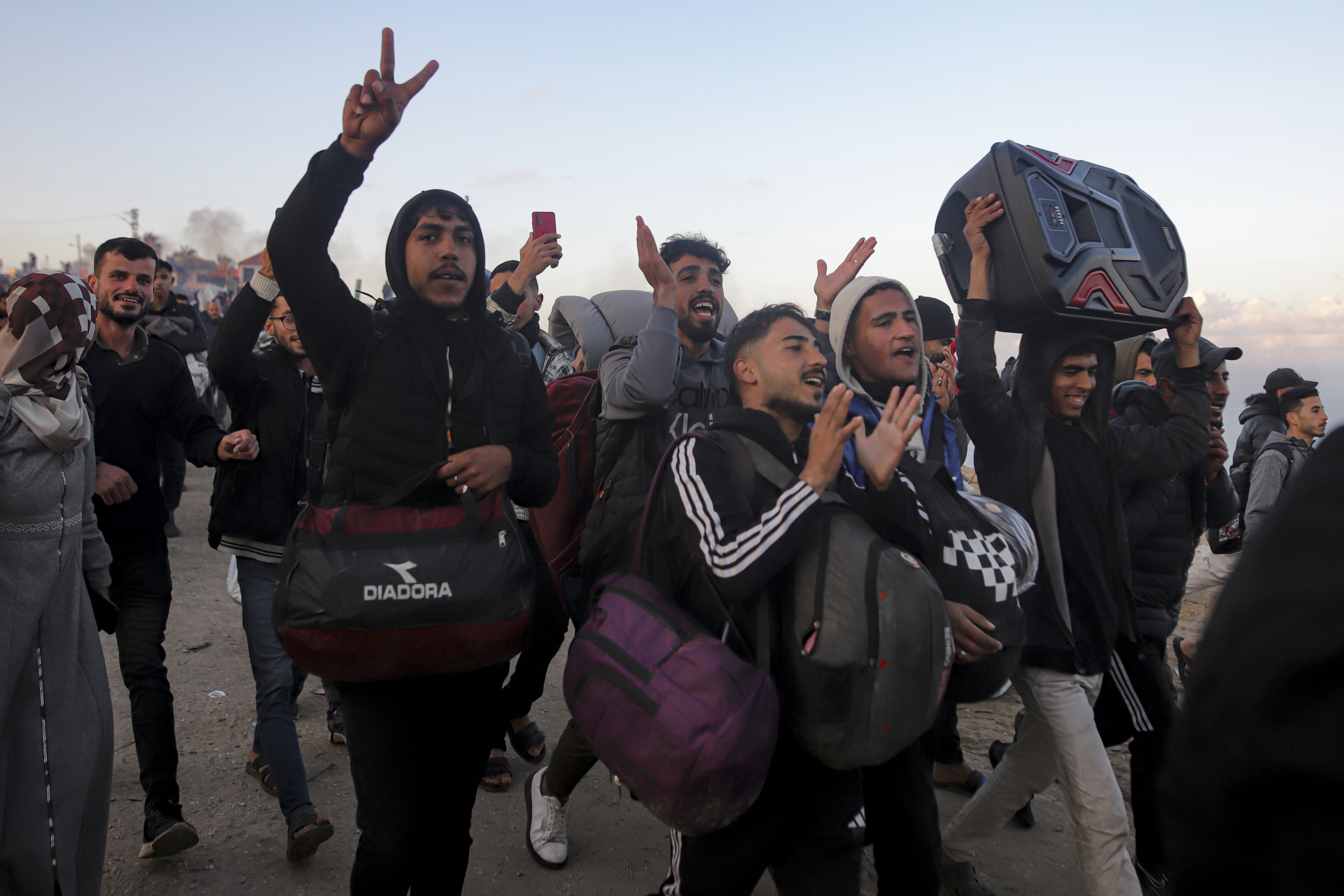 Displaced Palestinians celebrate as they return to their homes.