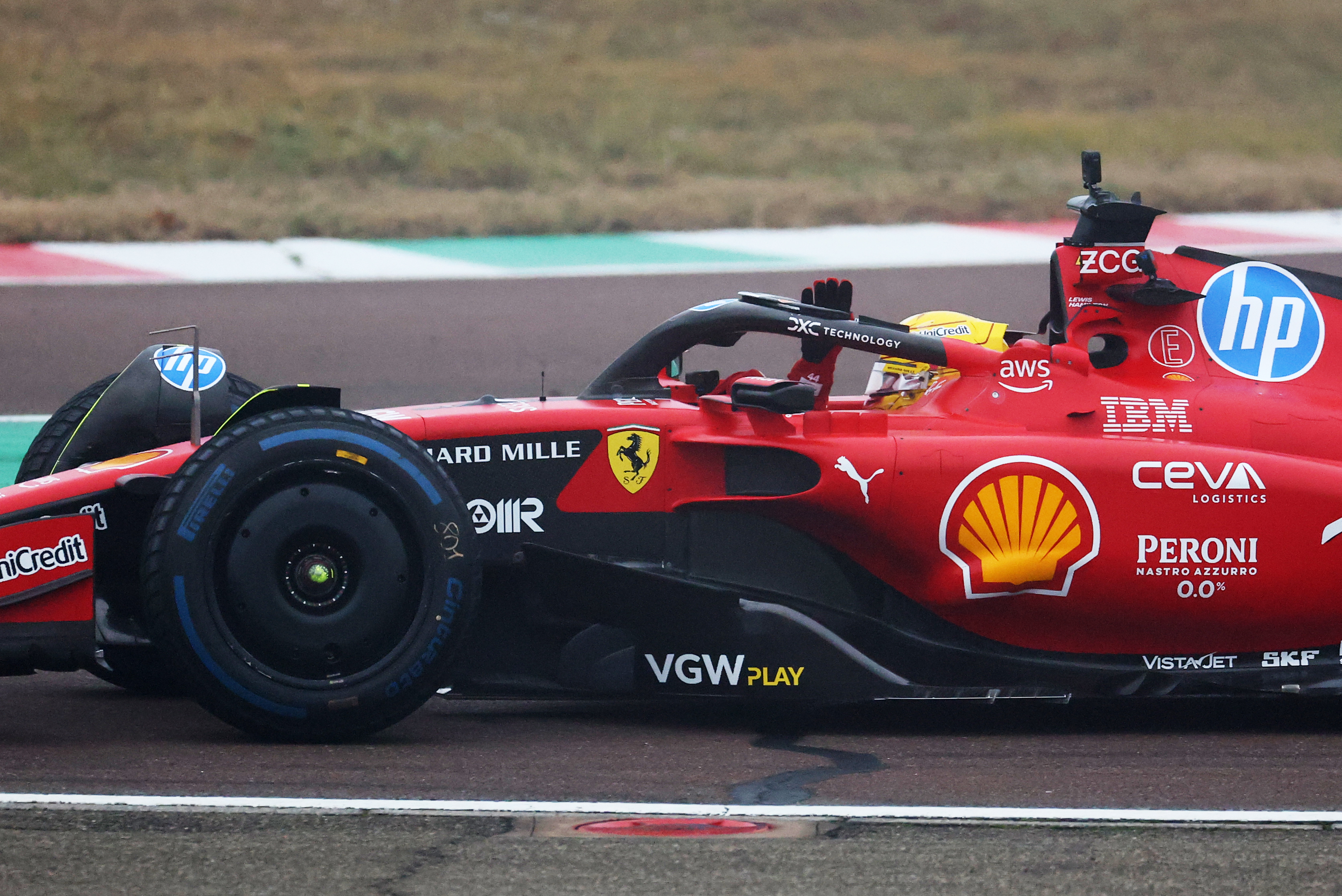 British racer Lewis Hamilton waves to the crowd as he drives the Ferrari SF-23 during his first official days as a Scuderia Ferrari F1 driver at Fiorano Circuit in Fiorano Modenese, Italy on January 22, 2025