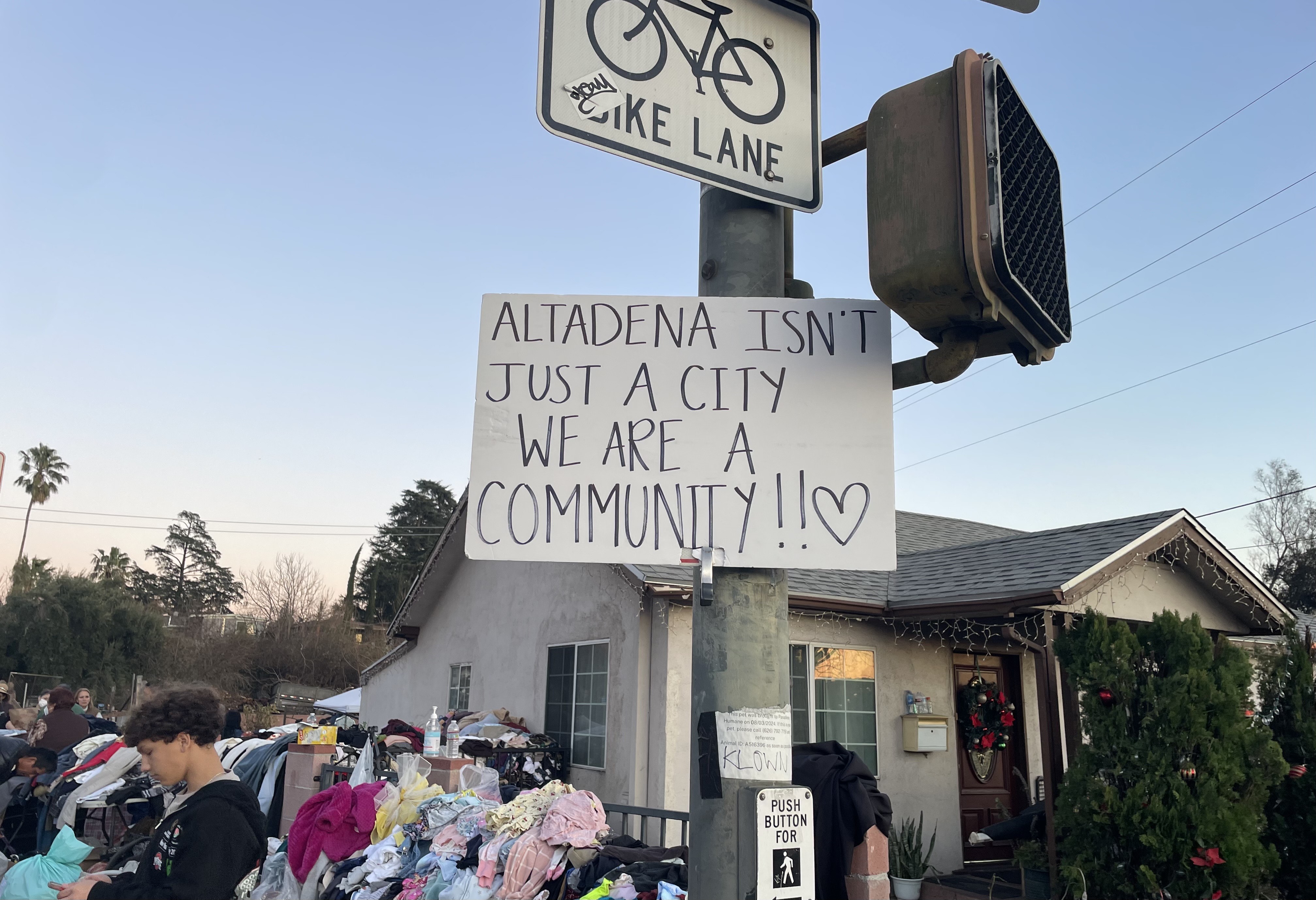A sign on a street pole reads: "Altadena is not just a city. We are a community."