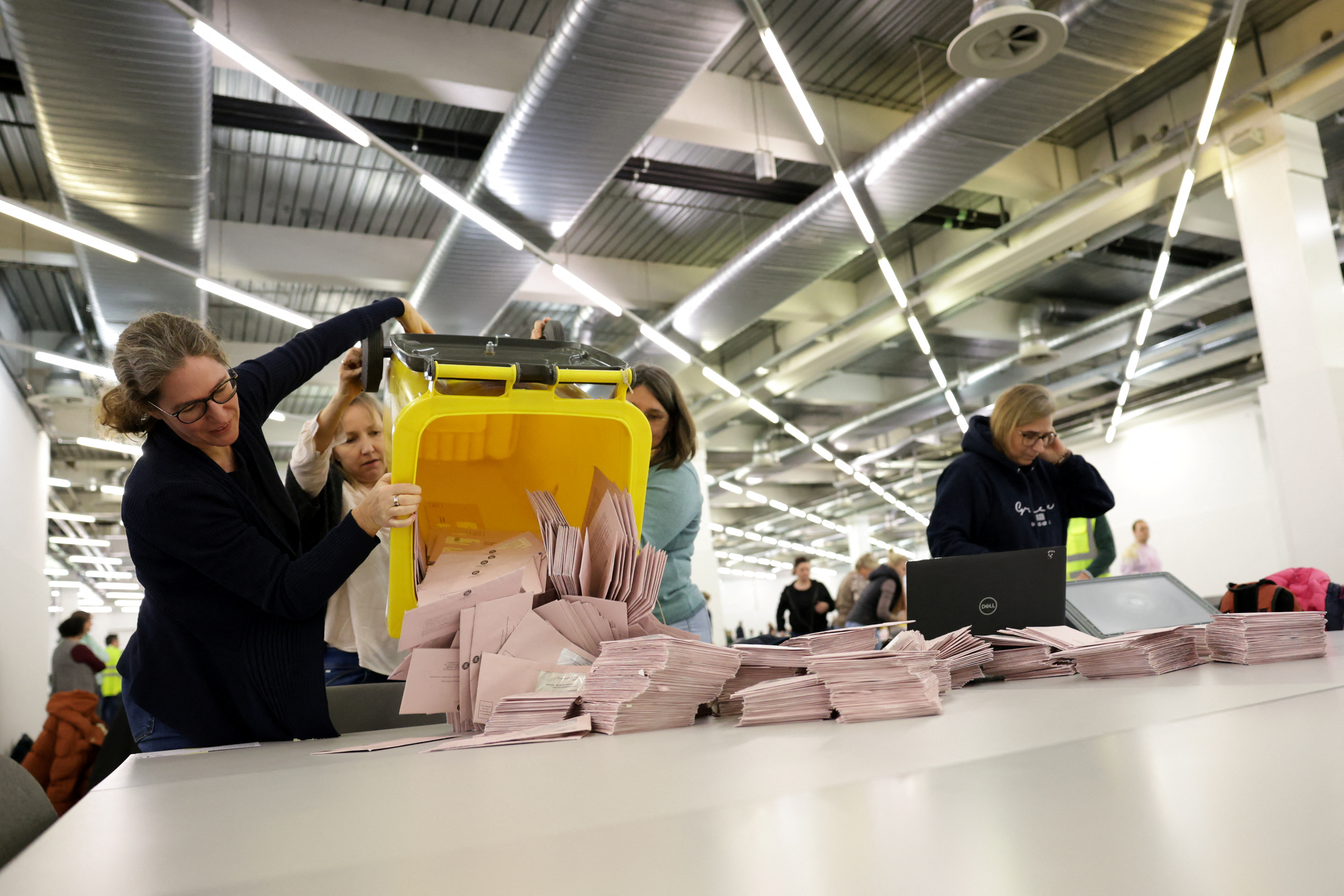 German election workers prepare and sort postal votes before polls close