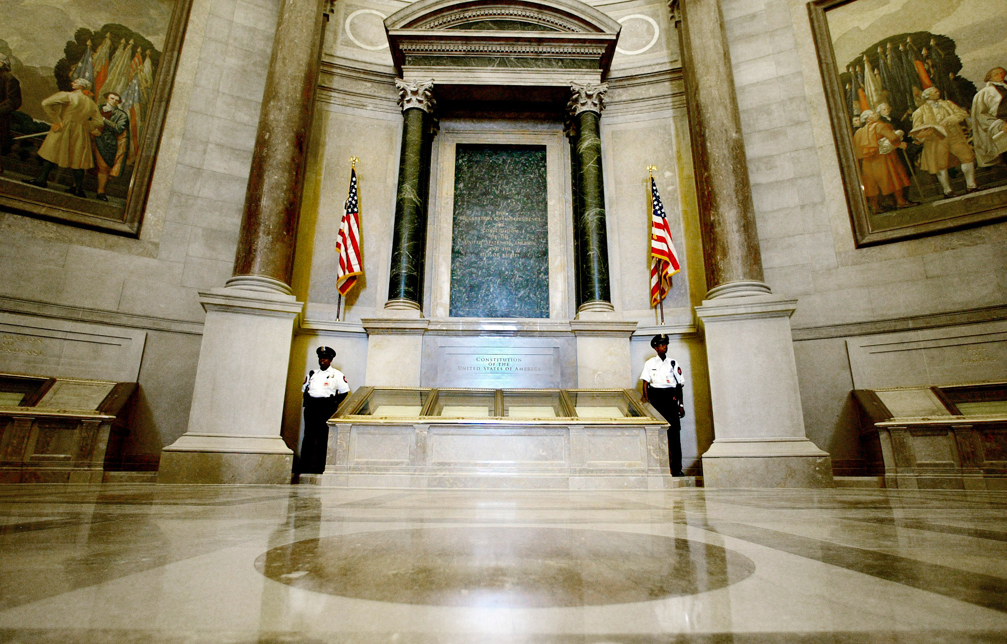 Guards stand next to the U.S. Constitution in the newly renovated Rotunda of the National Archives in Washington Tuesday, Sept. 16, 2003, during a media tour. Remounted in a newly refurbished rotunda at the National Archives, America's most important historical documents will soon be on display again in the nation's capital. And for the first time, all four pages of the Constitution will be on view, instead of just the first and last pages. The Archives opens to the public starting Thursday. (AP Photo/Ron Edmonds)