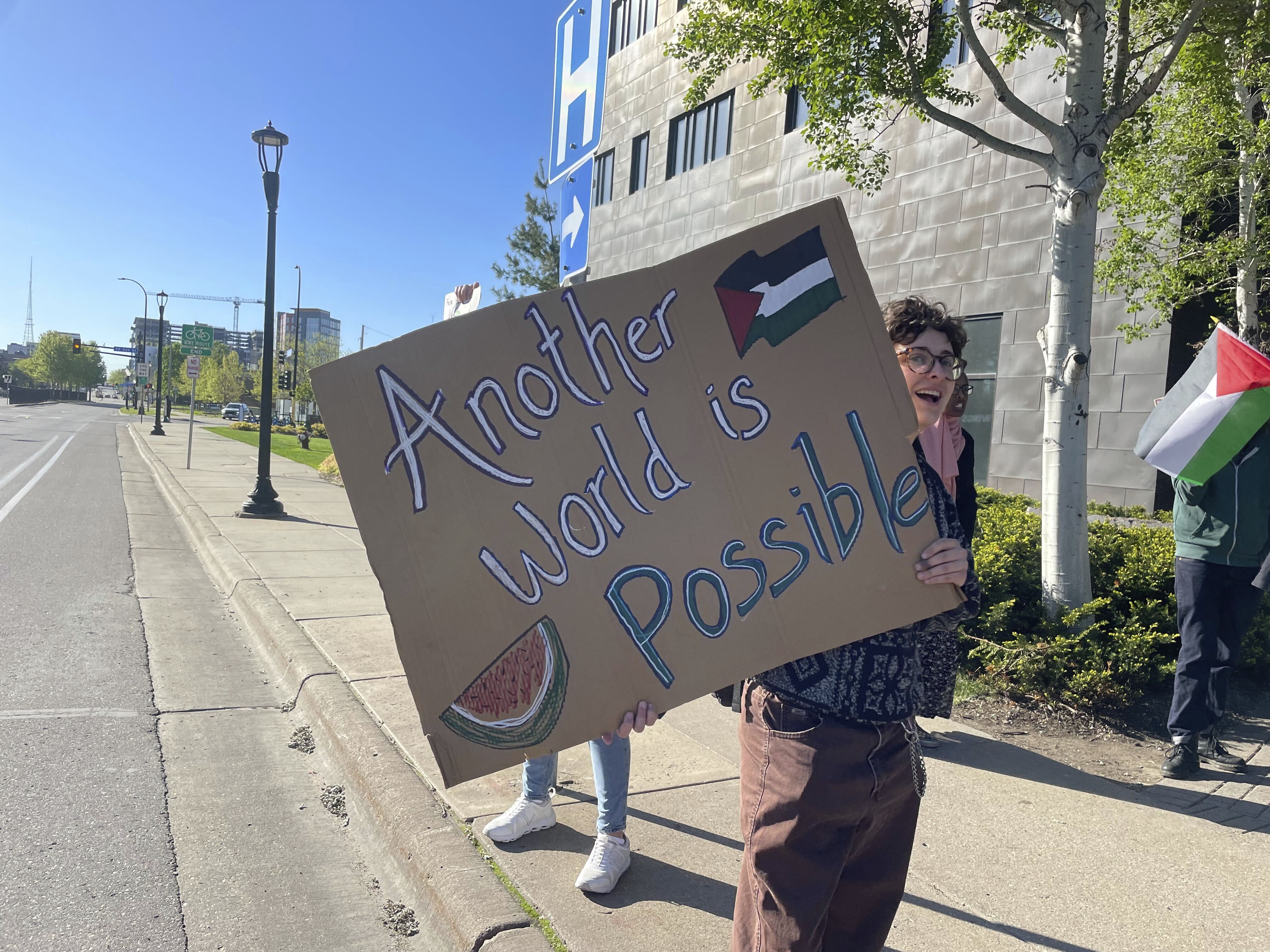 Pro-Palestinian supporters demanding divestment from companies that profit off the Israel-Hamas war, hold signs outside as the University of Minnesota's Board of Regents meet
