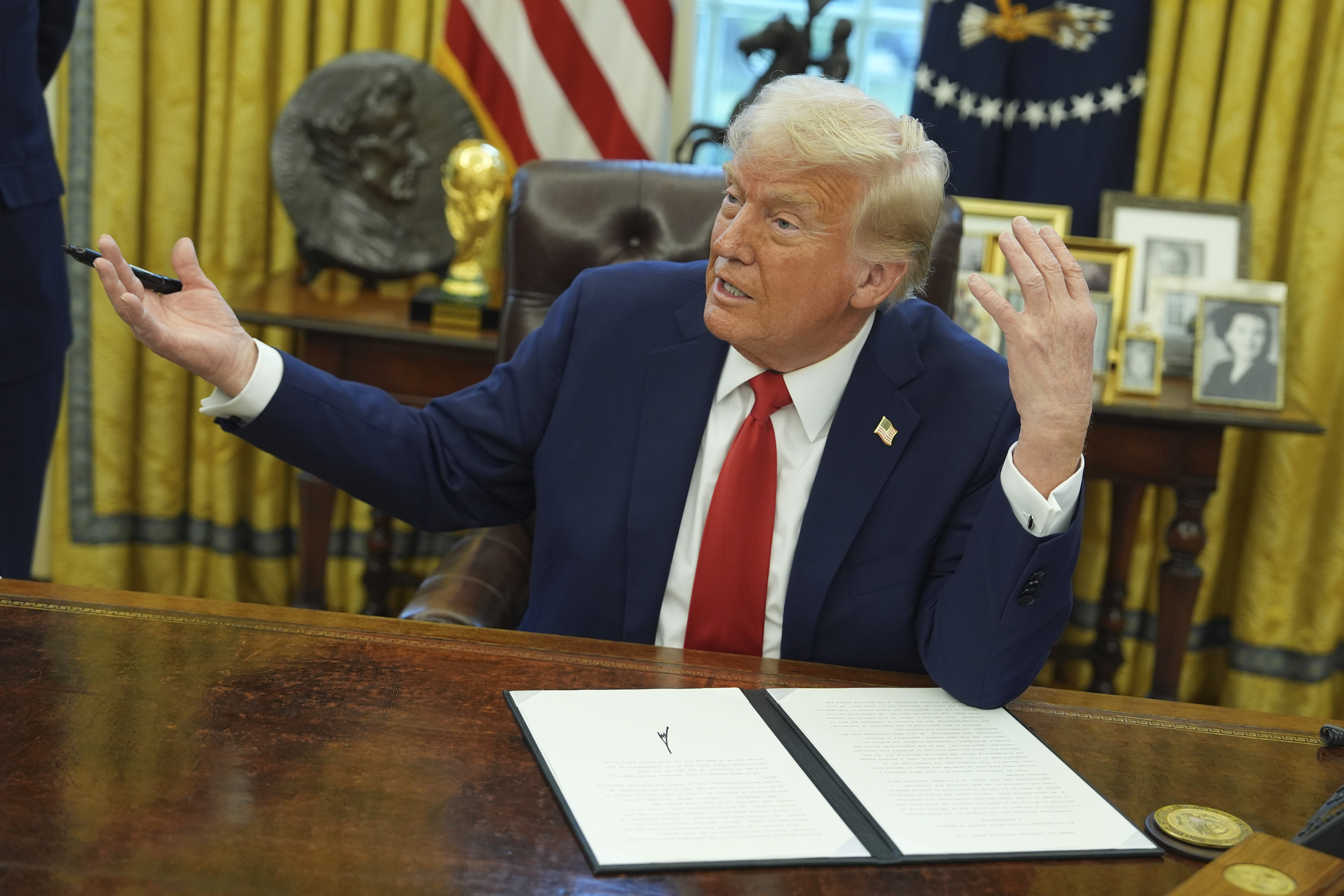President Donald Trump speaks as he signs an executive order in the Oval Office of the White House in the US