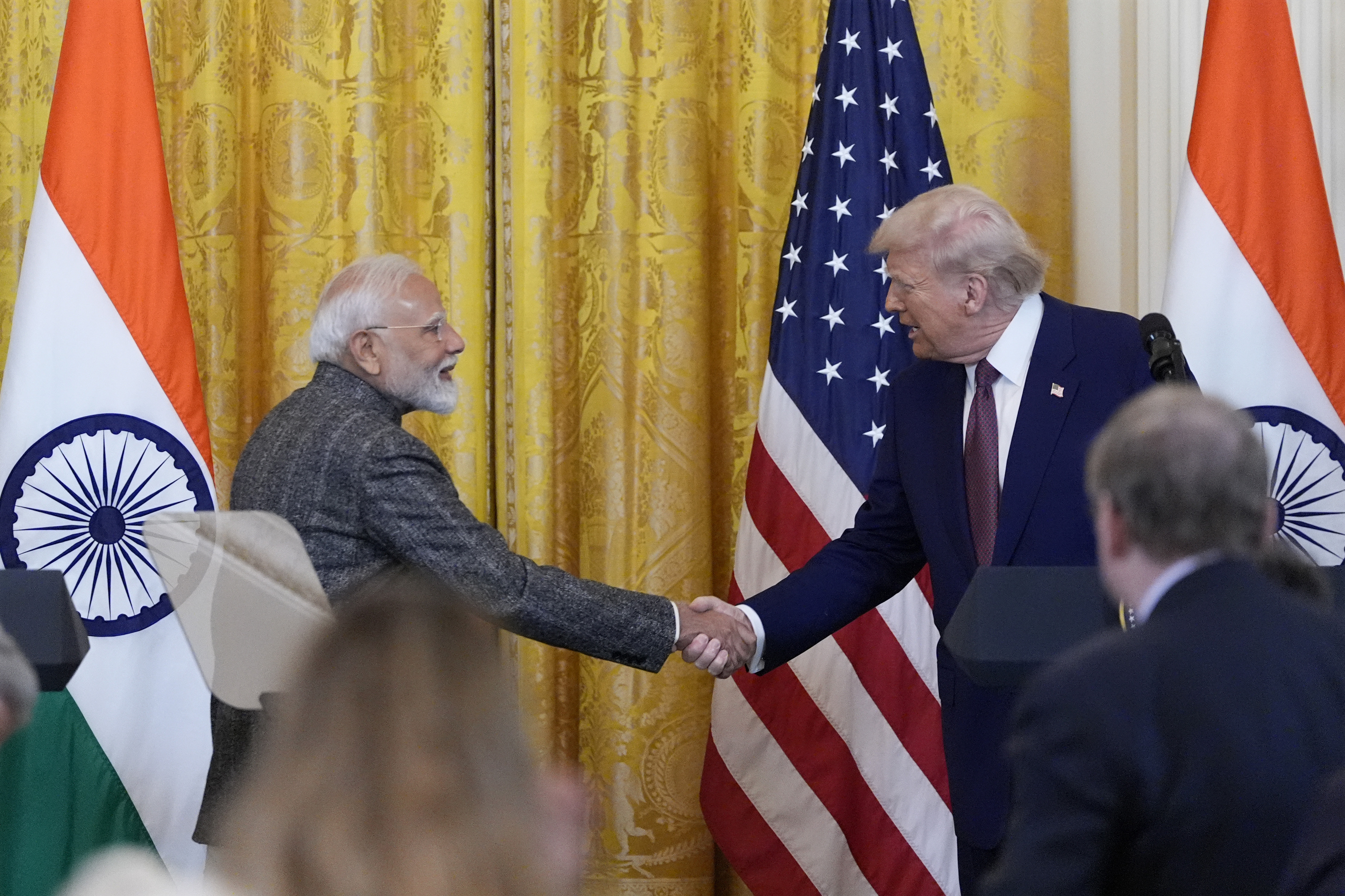 Narendra Modi and Donald Trump shake hands.