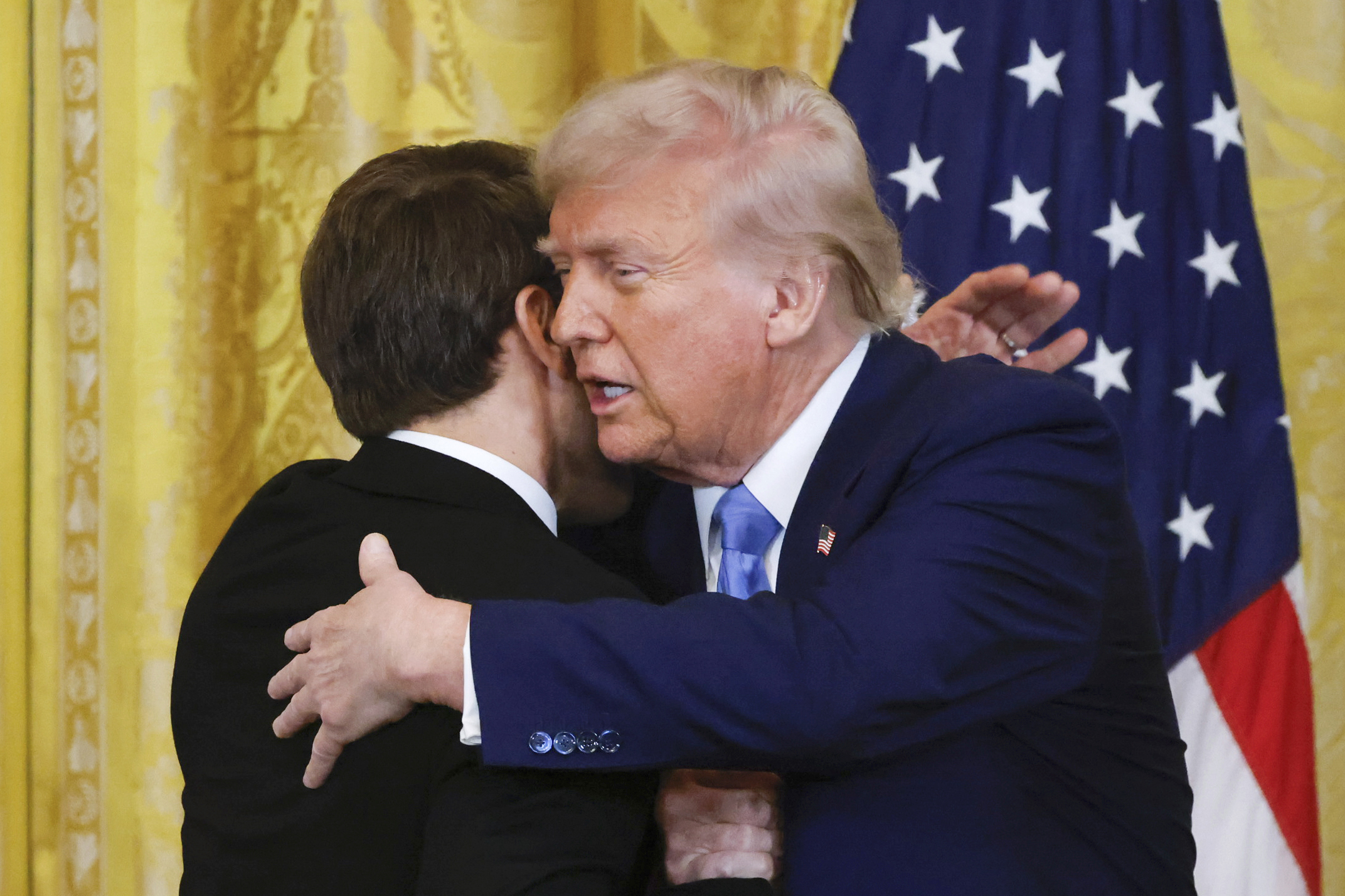 Donald Trump hugs Emmanuel Macron