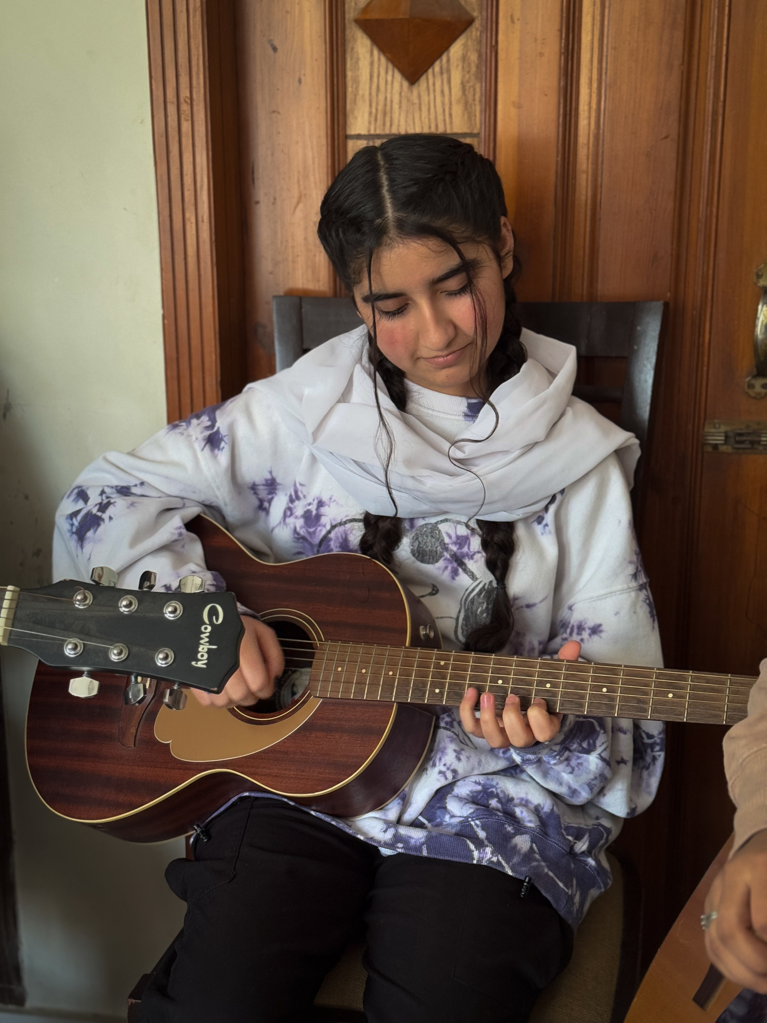 Shukriya strums her guitar during a practice session at Jellybean’s house in Islamabad, Pakistan on February 14, 2025