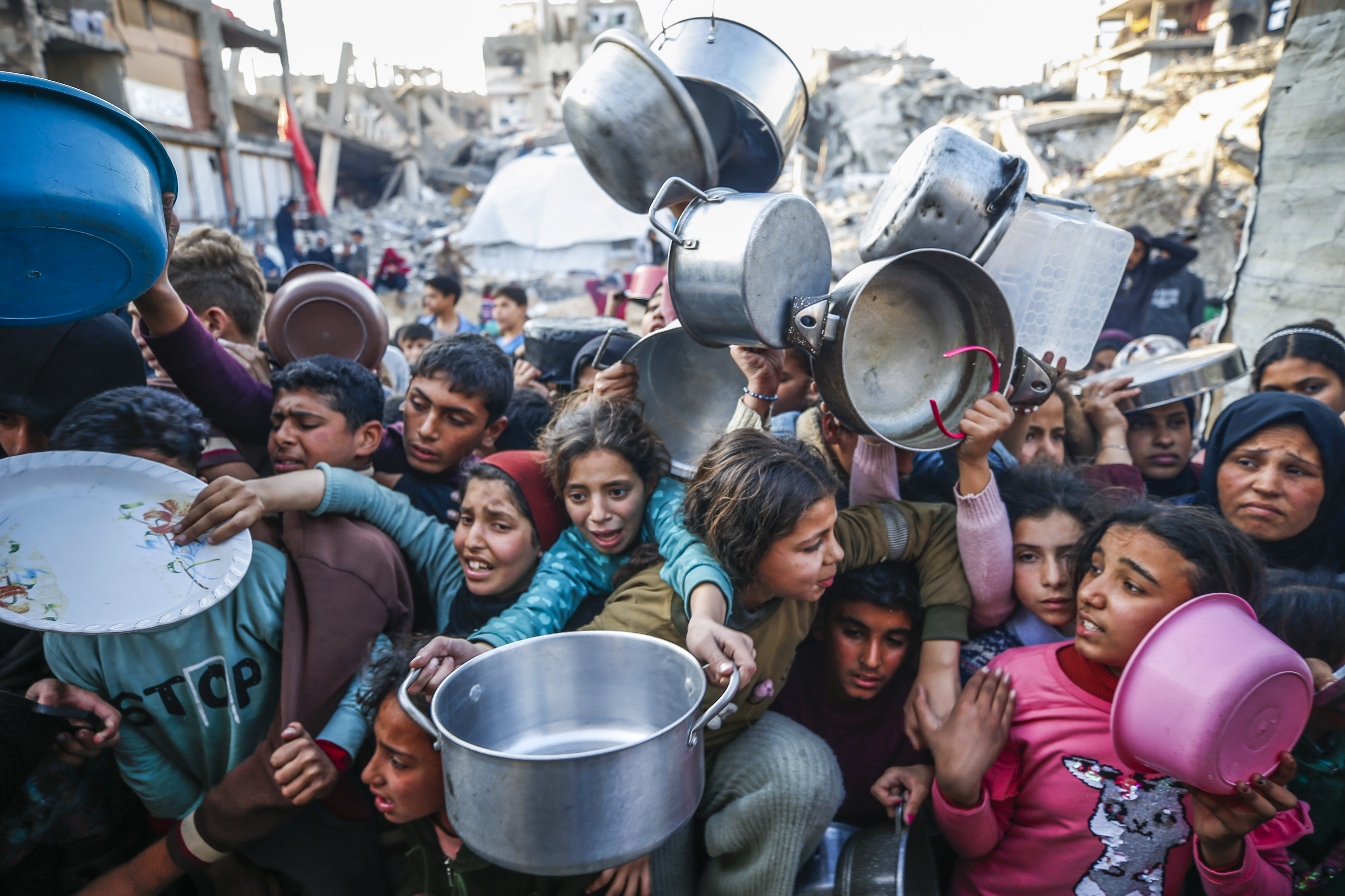 Palestinian children wait in long queues to get food at the Jabalia refugee camp in the Gaza Strip on March 11, 2025, after Israel stopped all humanitarian aid from entering the Gaza Strip [Mahmoud Issa/Anadolu]
