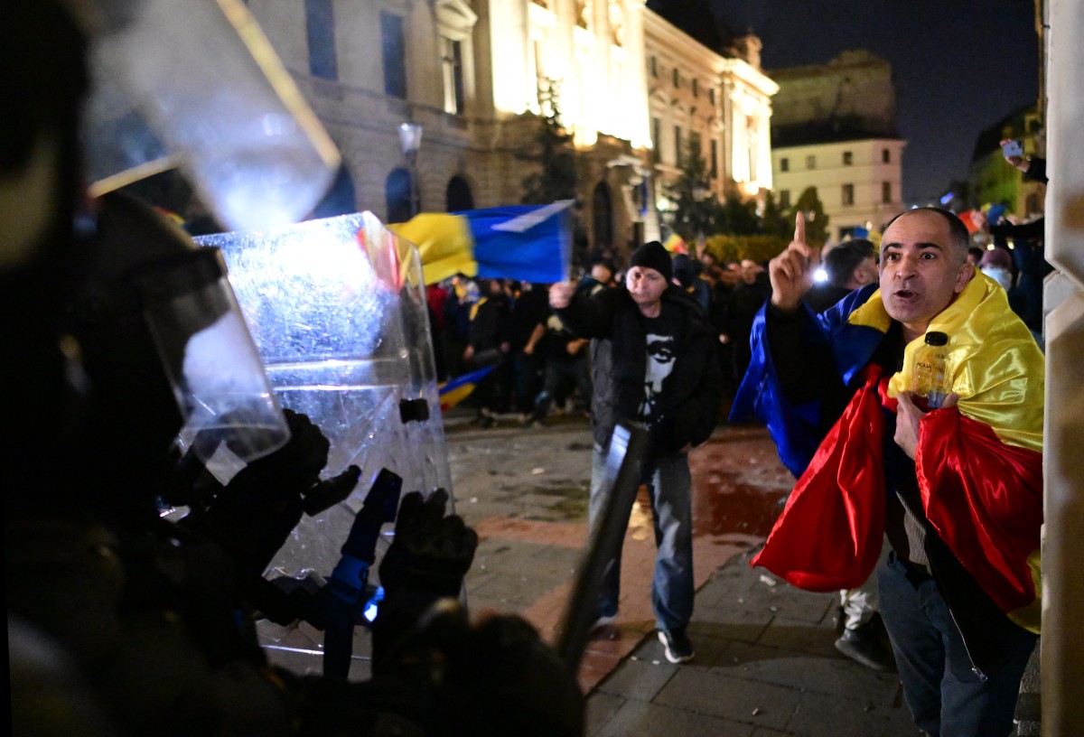 Supporters of presidential candidate Calin Georgescu clash with police during a protest next to Central Electoral Bureau in Bucharest on March 9, 2025 [Daniel Mihailescu/AFP]