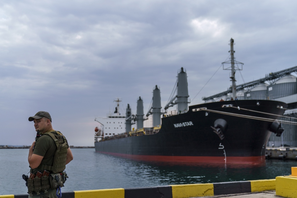 FILE - A security officer stands next to the ship Navi-Star which sits full of grain since Russia's invasion of Ukraine began five months ago as it waits to sail from the Odesa Sea Port, in Odesa, Ukraine, on July 29, 2022. Russia has repeatedly fired missiles and drones at Ukrainian ports key to sending grain to the world. Moscow has declared large swaths of the Black Sea dangerous for shipping. (AP Photo/David Goldman, File)