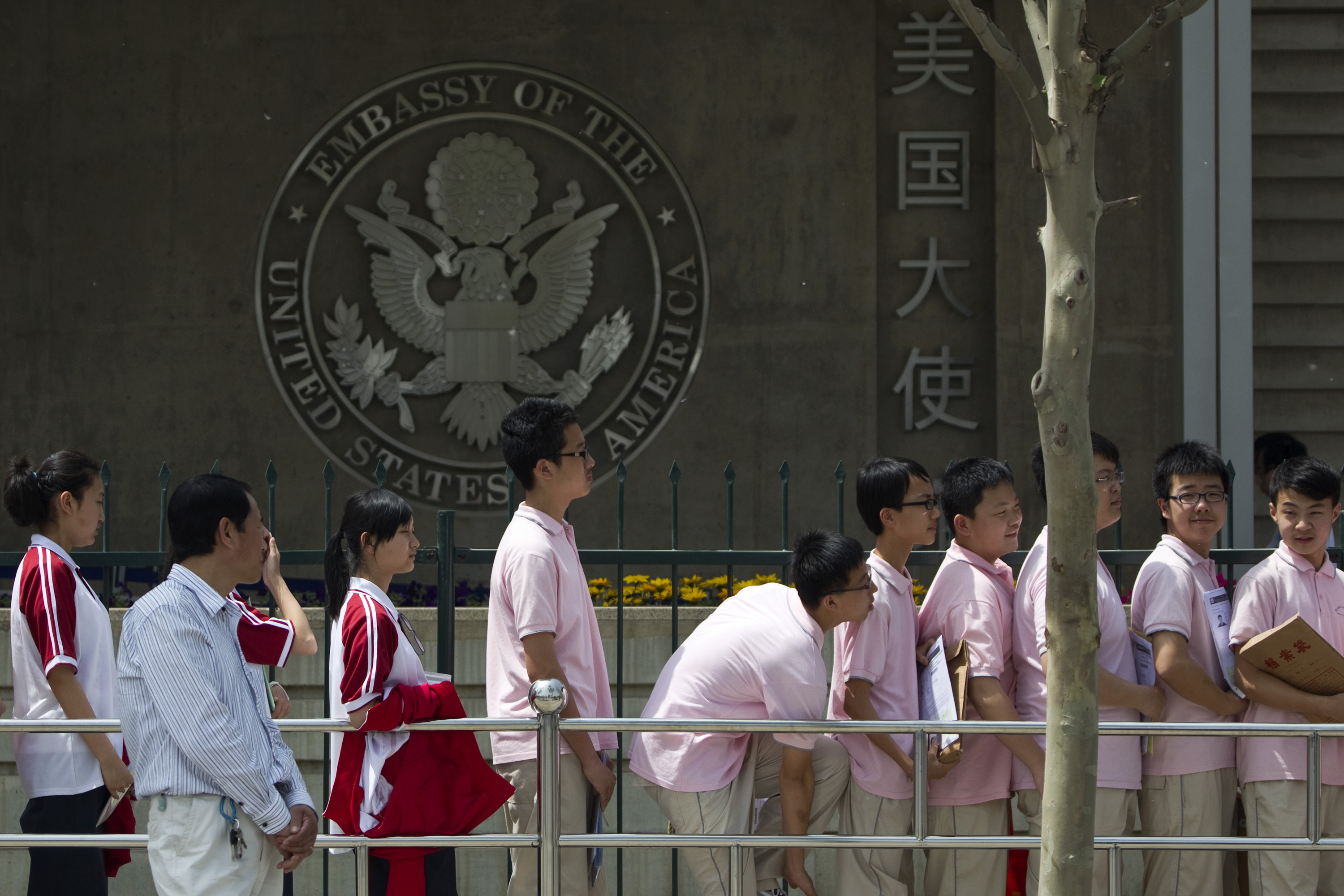 Chinese students wait outside the US Embassy for their visa application interviews on May 2, 2012, in Beijing. Over the past four decades, US universities have educated millions of Chinese students, many of whom have stayed in the country and become top researchers and distinguished professors. (AP Photo/Alexander F. Yuan, File)