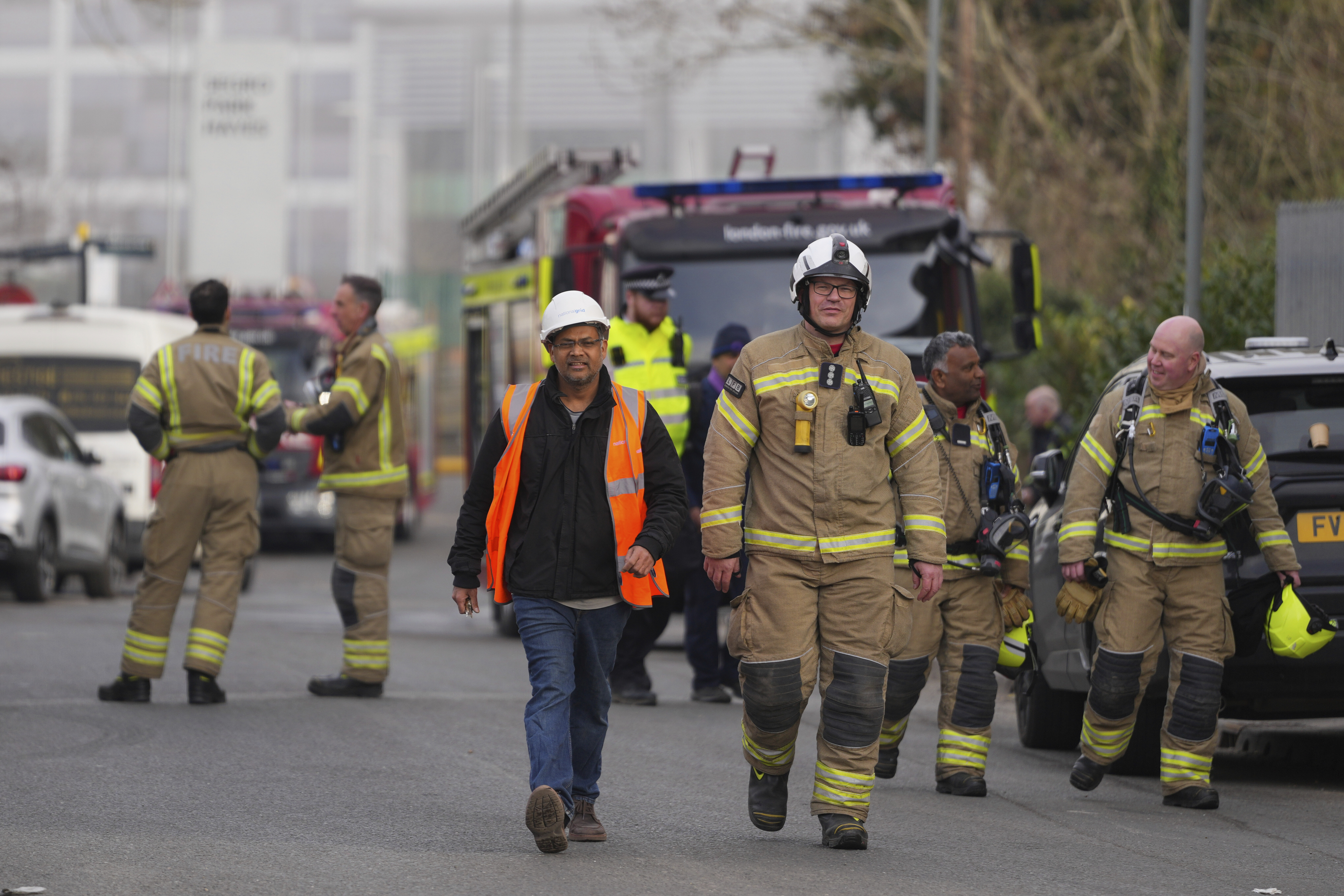Firefighters wait at the area around the North Hyde electrical substation, which caught fire on Thursday night and led to a closure of Heathrow airport in London, on Friday, March 21, 2025