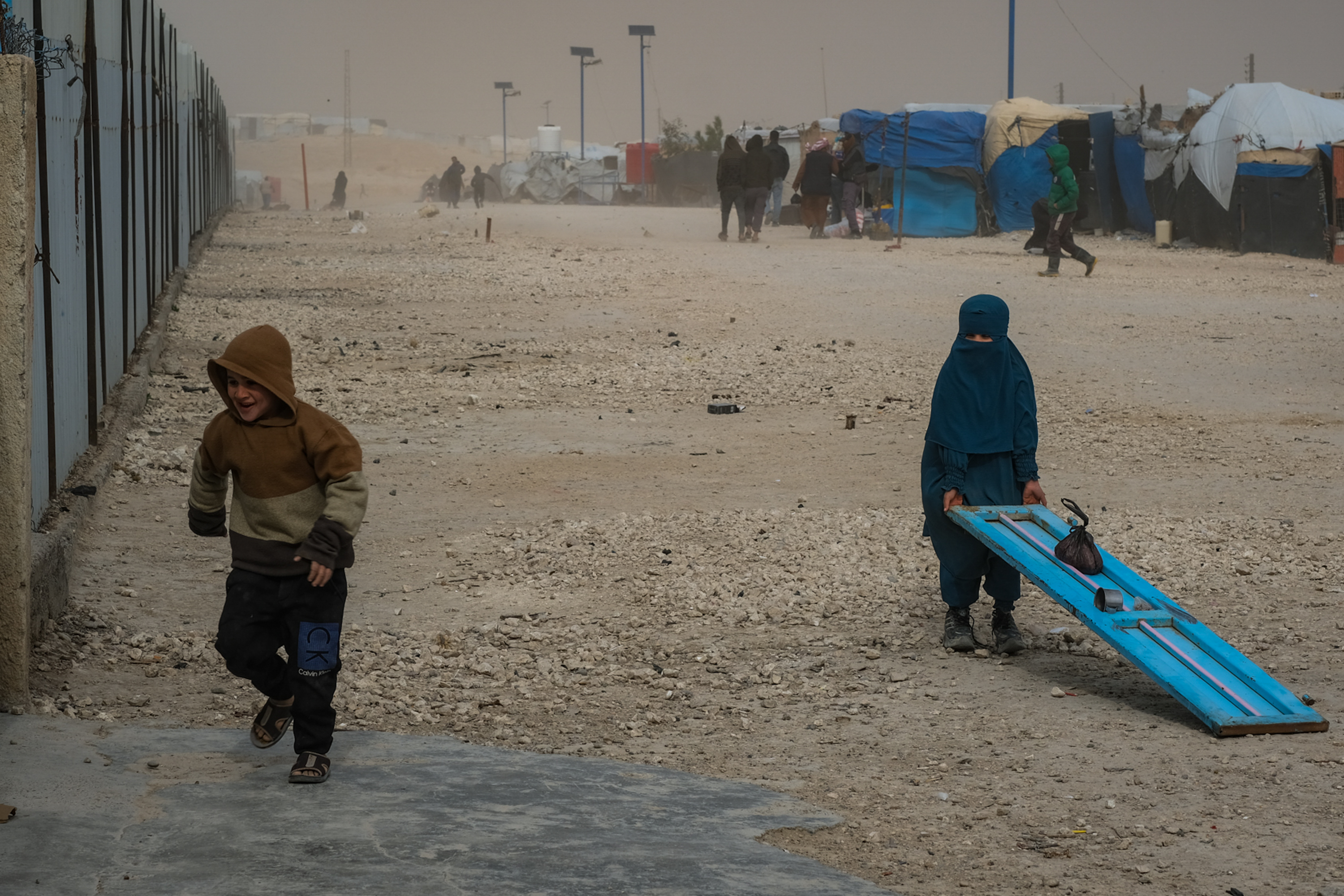 Children play in a sandstorm in Al-Hol, February 2025