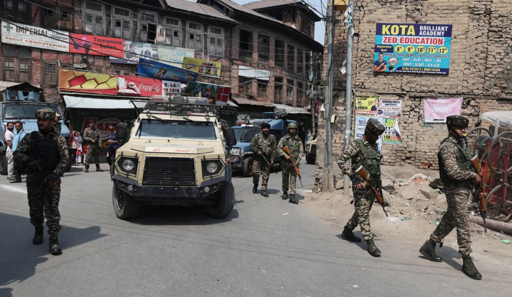 Indian paramilitary soldiers stand guard during a procession.